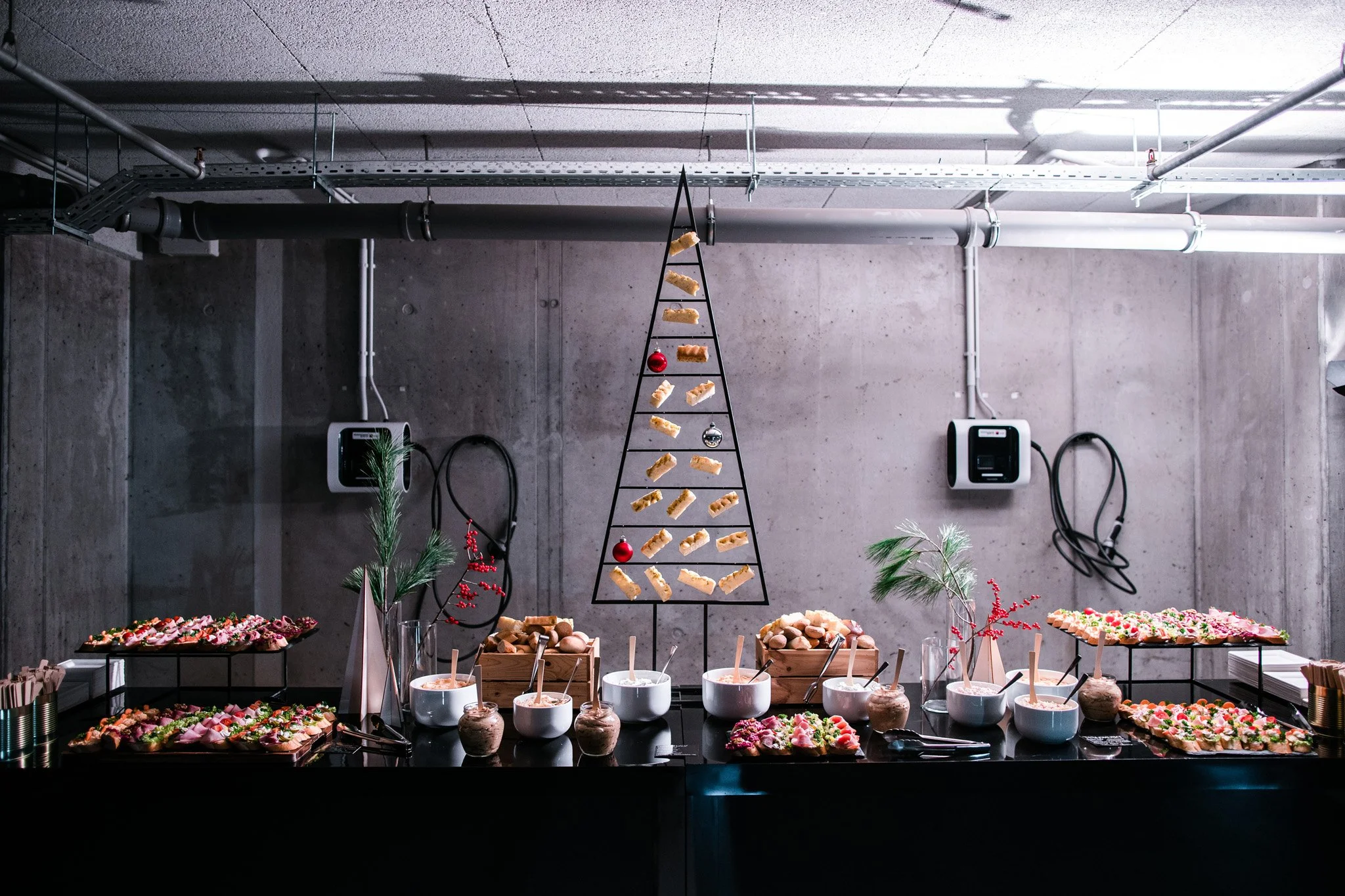 A festive holiday food spread with a Christmas tree-shaped stand holding cookies, surrounded by bowls of dips and appetizers. Catering and food photography in Zürich, Zug, Bern, Lucerne, Basel, St. Gallen and across Switzerland.