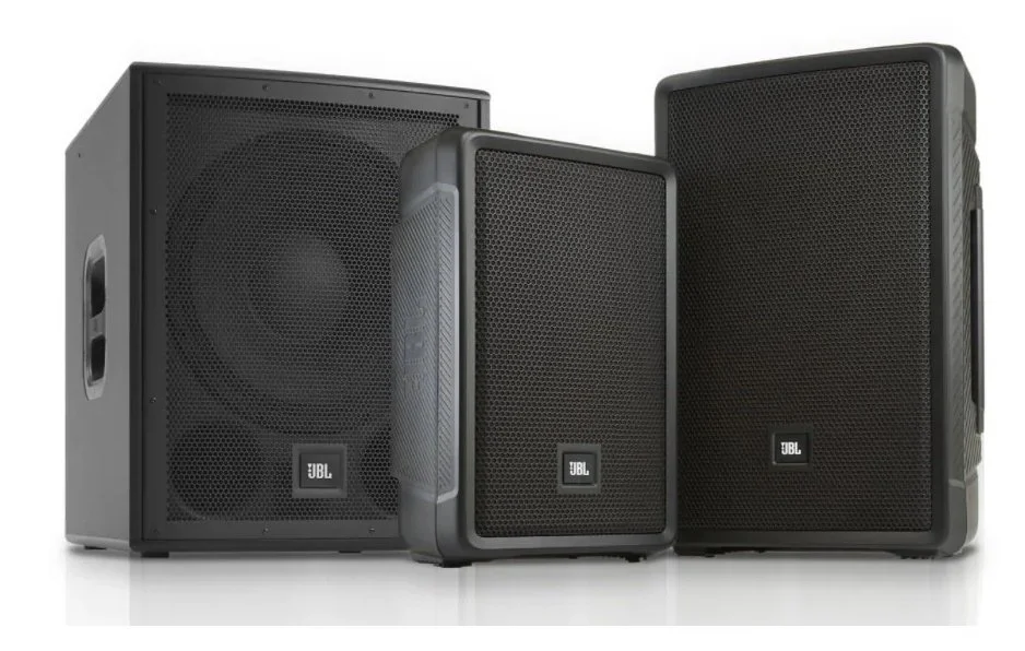 Three black JBL portable speaker systems of different sizes arranged side by side, with a black subwoofer on the left.