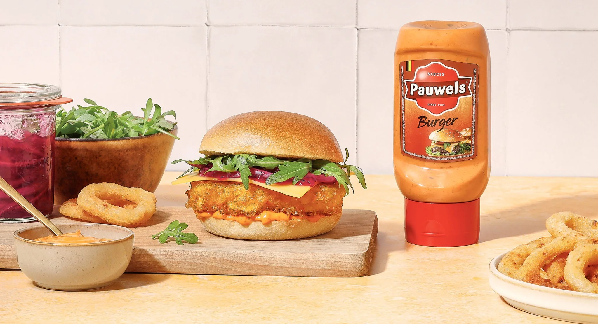 Sarah Ghijselinck, food and drink stylist, art direction, recipe development, Gent. A crispy chicken burger and a bottle of burger sauce from pauwels sauzen