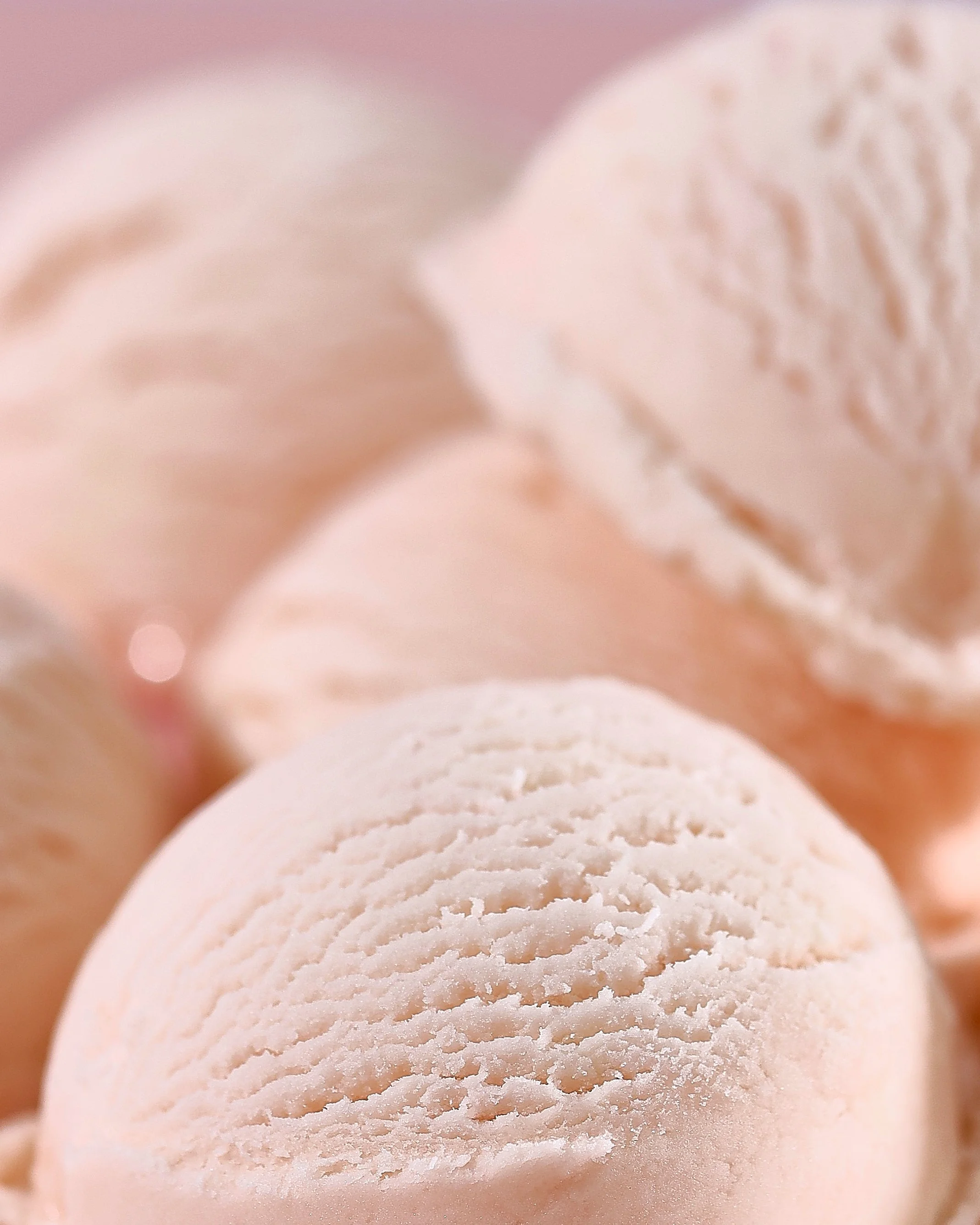 Sarah Ghijselinck food stylist, Close-up of several pink and cream-colored marshmallows with textured surfaces.