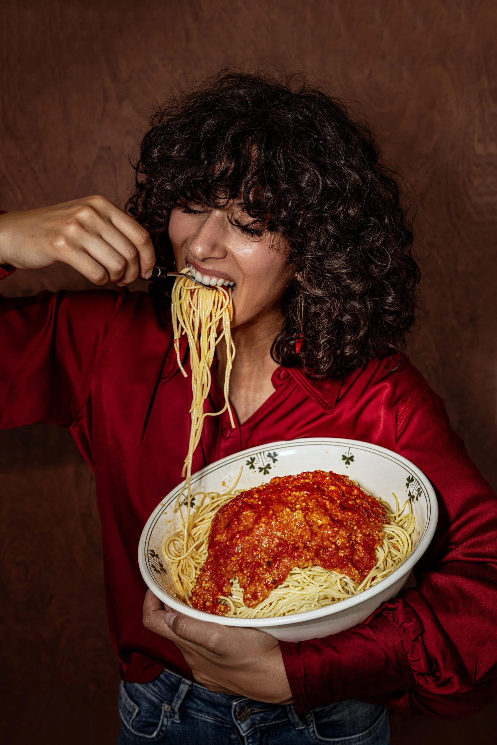 Sarah Ghijselinck, food and drink stylist, art direction, recipe development, Gent, restaurant photography, Levi's burgers, Woman with curly hair wearing a red shirt, eating spaghetti 