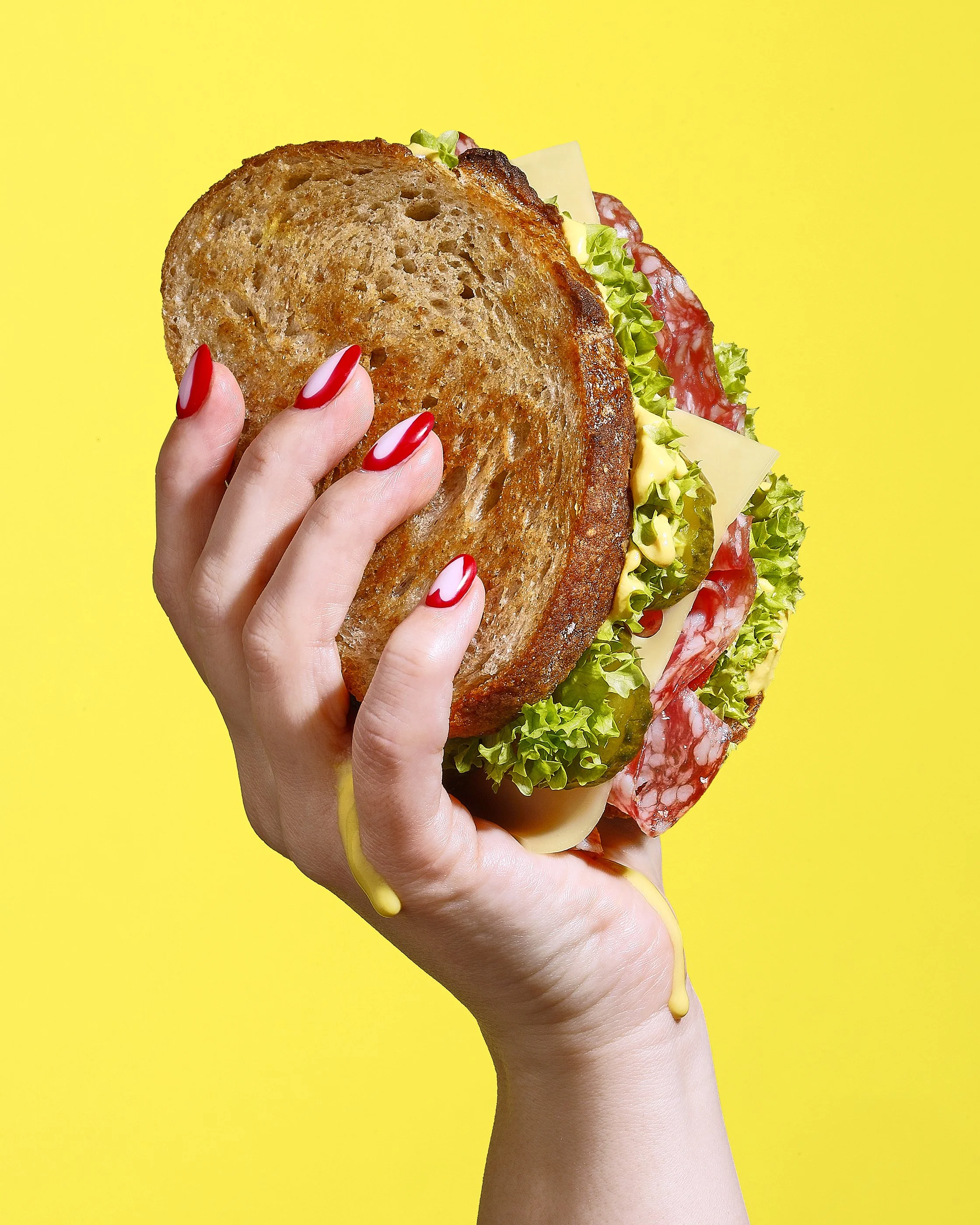 Sarah Ghijselinck, food and drink stylist, art direction, Gent, Hand holding a sandwich.