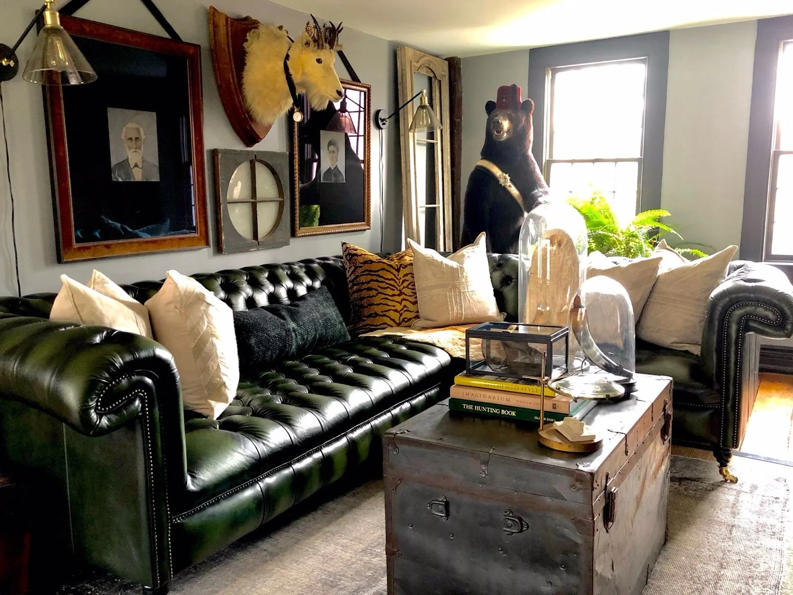 A rich-green leather corner sofa in a home with a rustic aesthetic