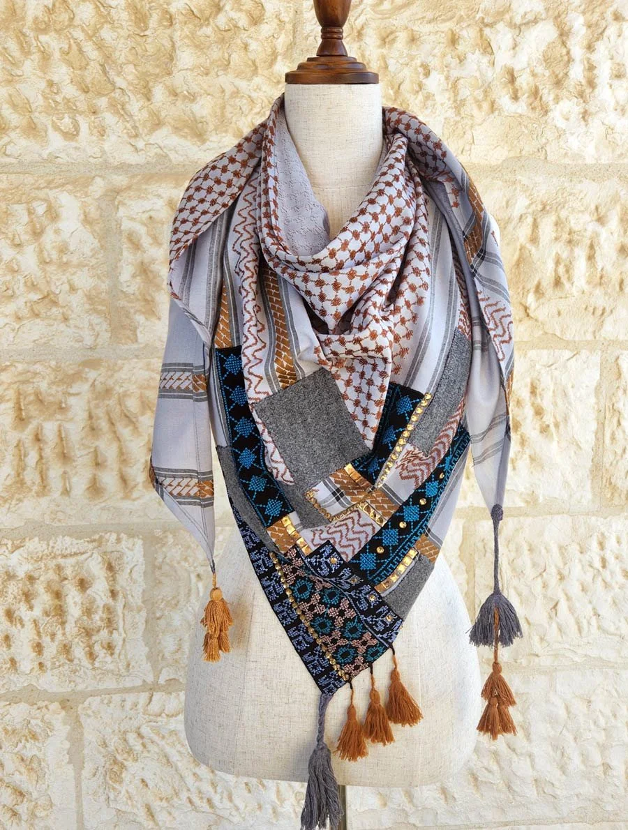 Wrap yourself in timeless style with this Keffiyeh Triangle Scarf, beautifully accented with Palestinian Embroidery, strass and tweed patches made from 20% natural wool.