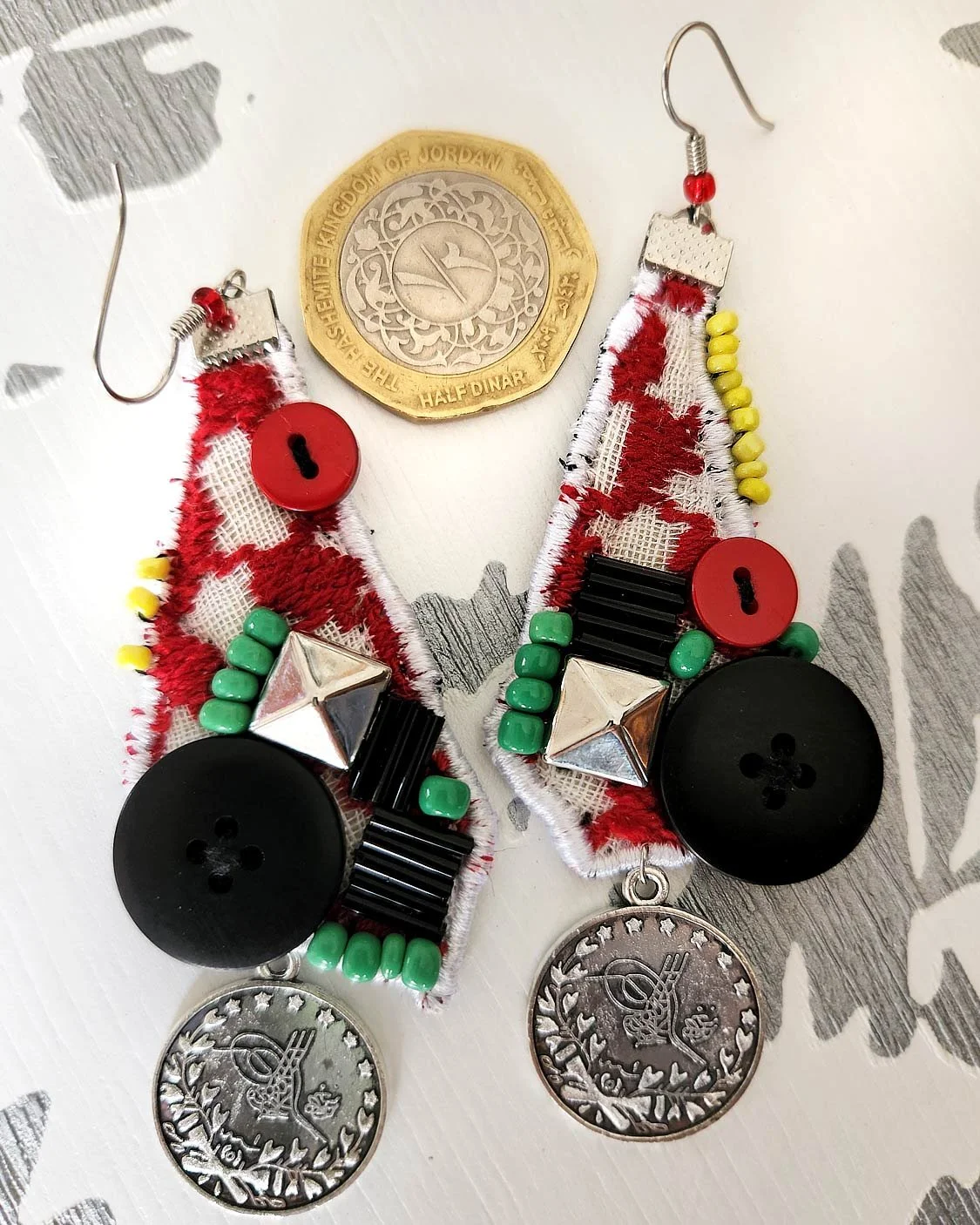 What makes this free form earring special is the Keffiyeh pattern in the background with charm, beads, buttons and Palestinian embroidery