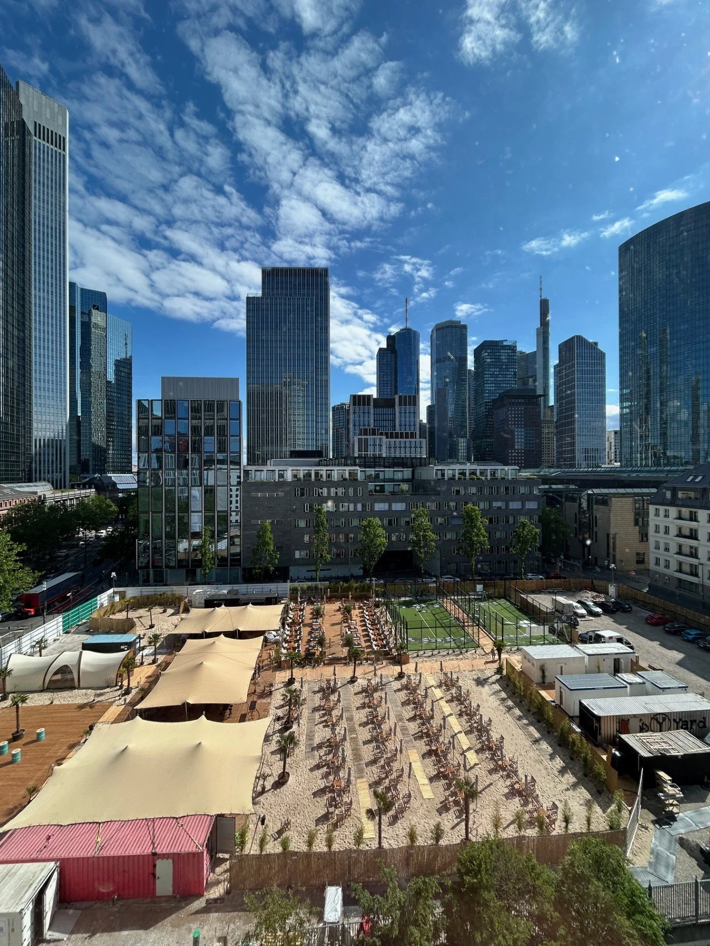 View of Frankfurt cityscape with tall modern skyscrapers, a Gibson Beach club, padel ball, short walk to Alte Oper and Frankfurt Messe.