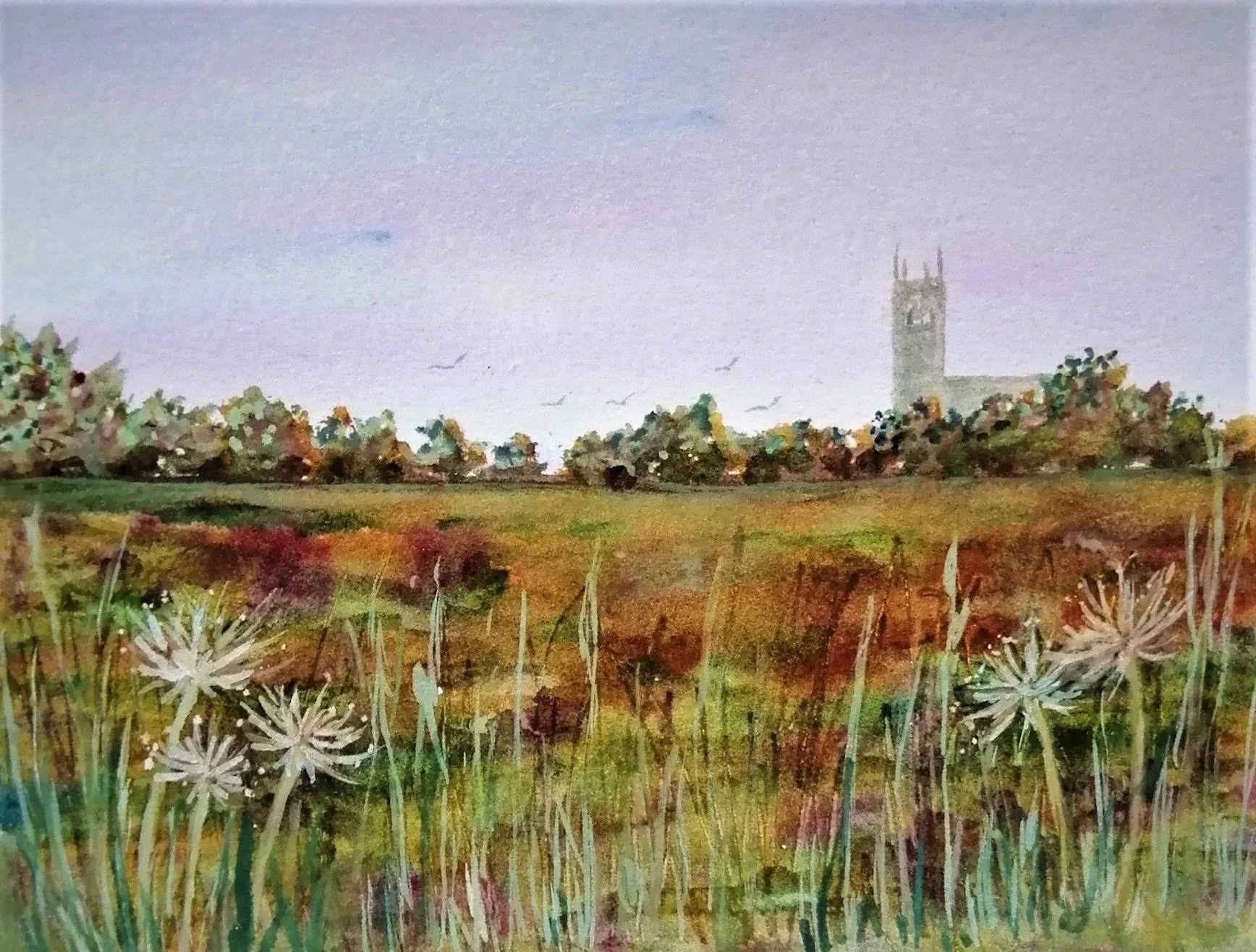 A watercolor painting of a landscape with tall grass and flowers in the foreground, a green field with trees in the middle ground, and a historic clock tower in the background under a pale, cloudy sky.