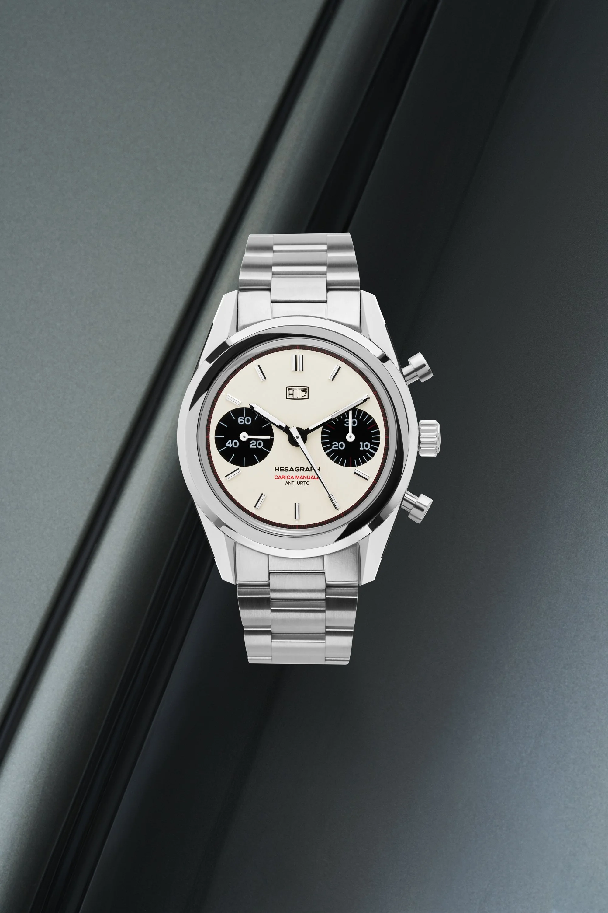 Still life di Hesagraph Cannoli, orologio cronografo di HTD watches su sfondo di una Porsche grigia