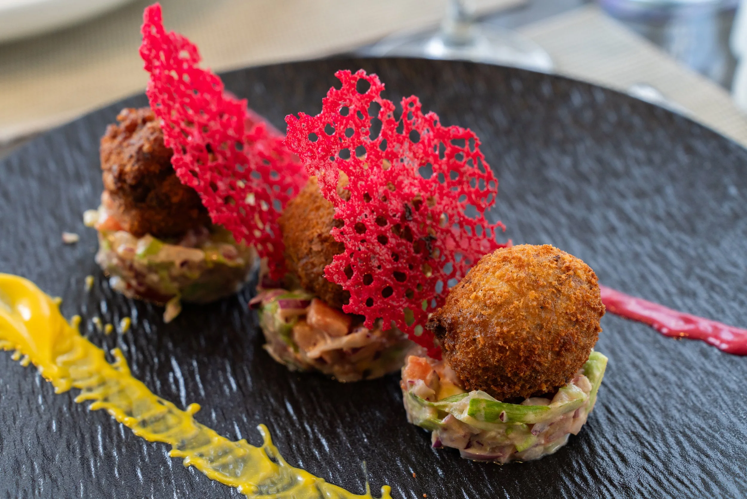 Assiette de tapas avec croquettes, légumes, décorations ketchup et moutarde.