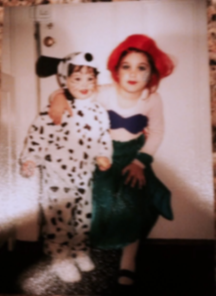 Two children in costumes posing together indoors.