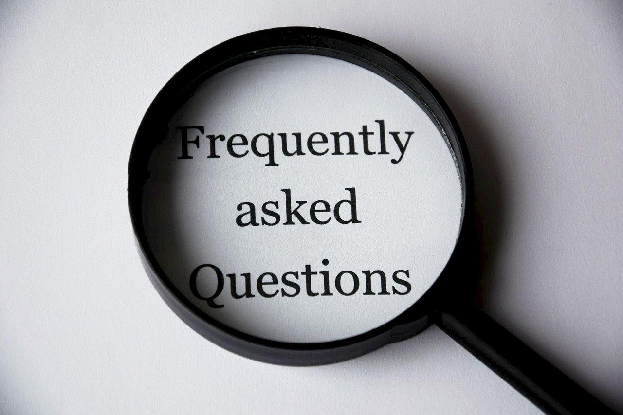 Magnifying glass with the words "Frequently asked Questions" inside the lens.