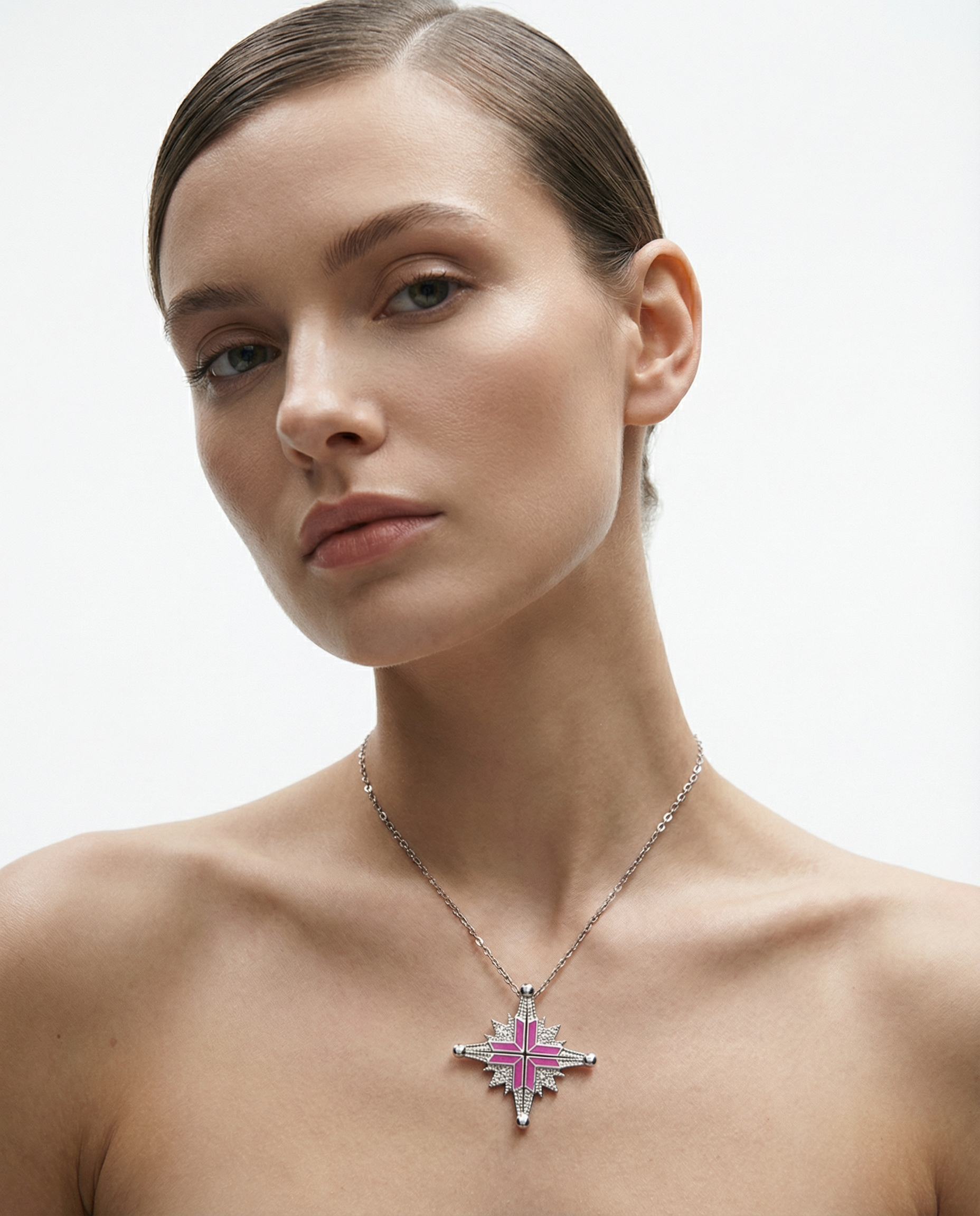 A woman with long dark hair, wearing a strapless white top and multiple gold jewelry, is reading a newspaper.