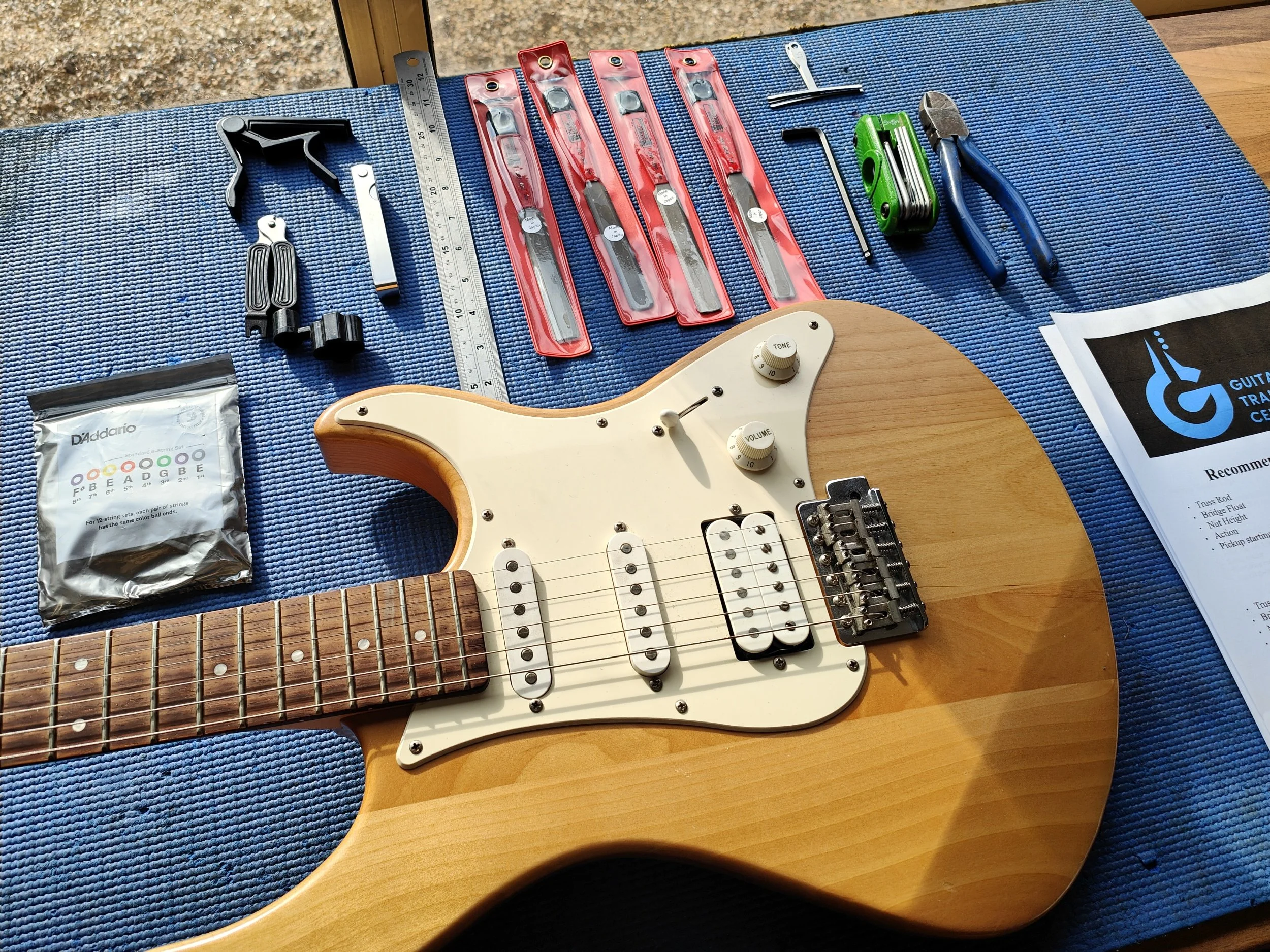 An electric, Yamaha, Guitar on a workbench surrounded by guitar repair tools.