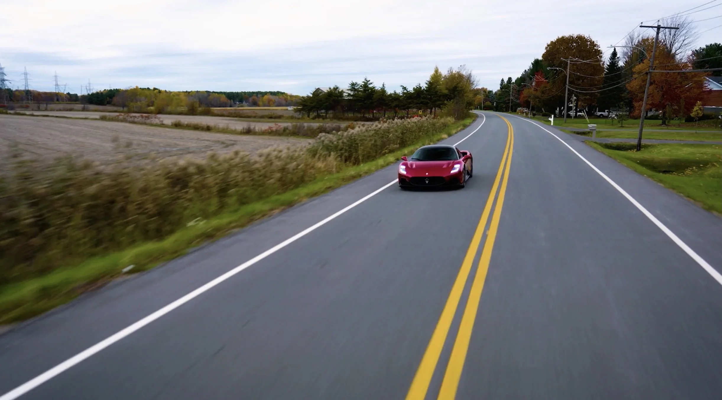 Red sports car on winding road with autumn foliage..jpg