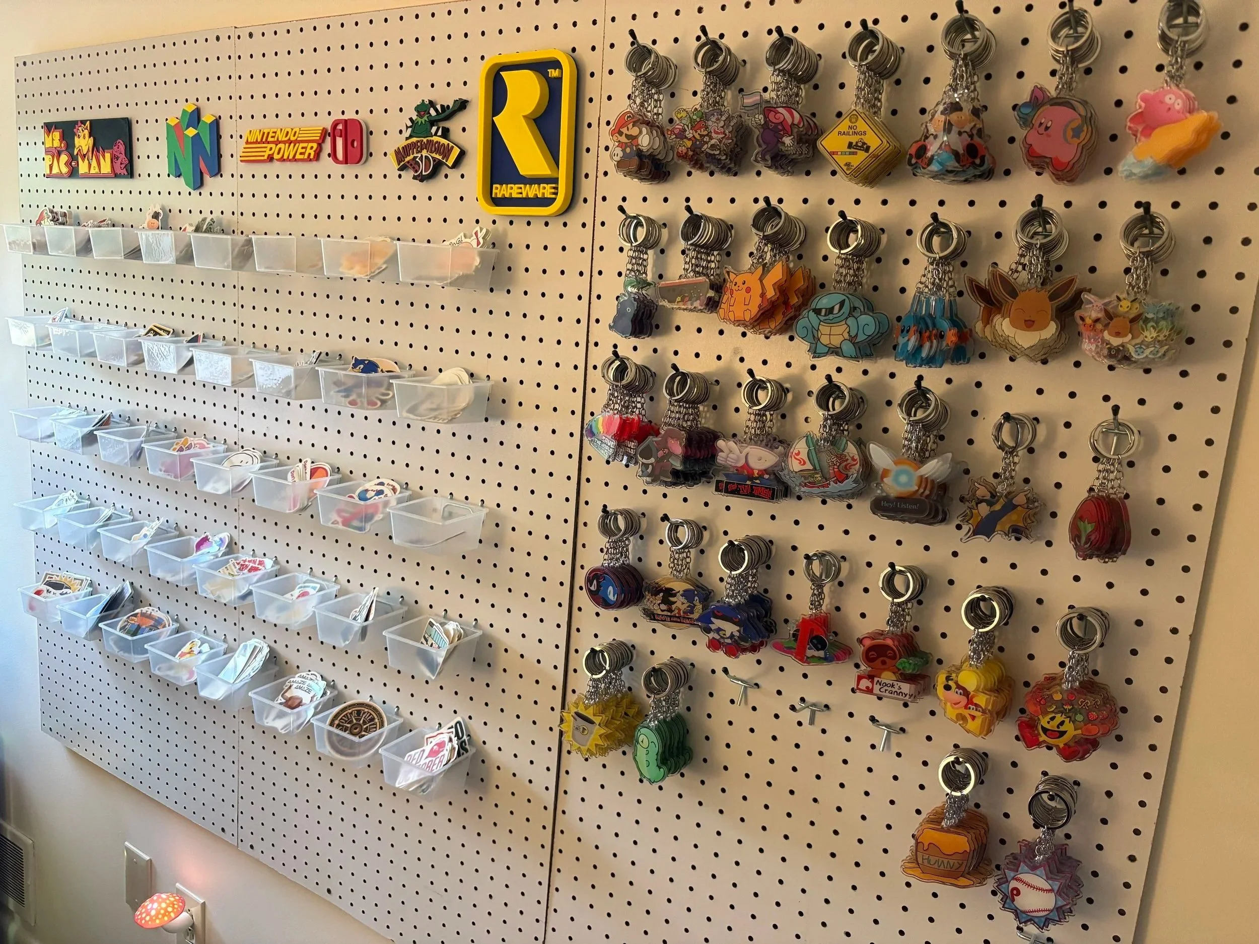 A photo of my workstation at home, where I keep my stock of stickers and keychains.
