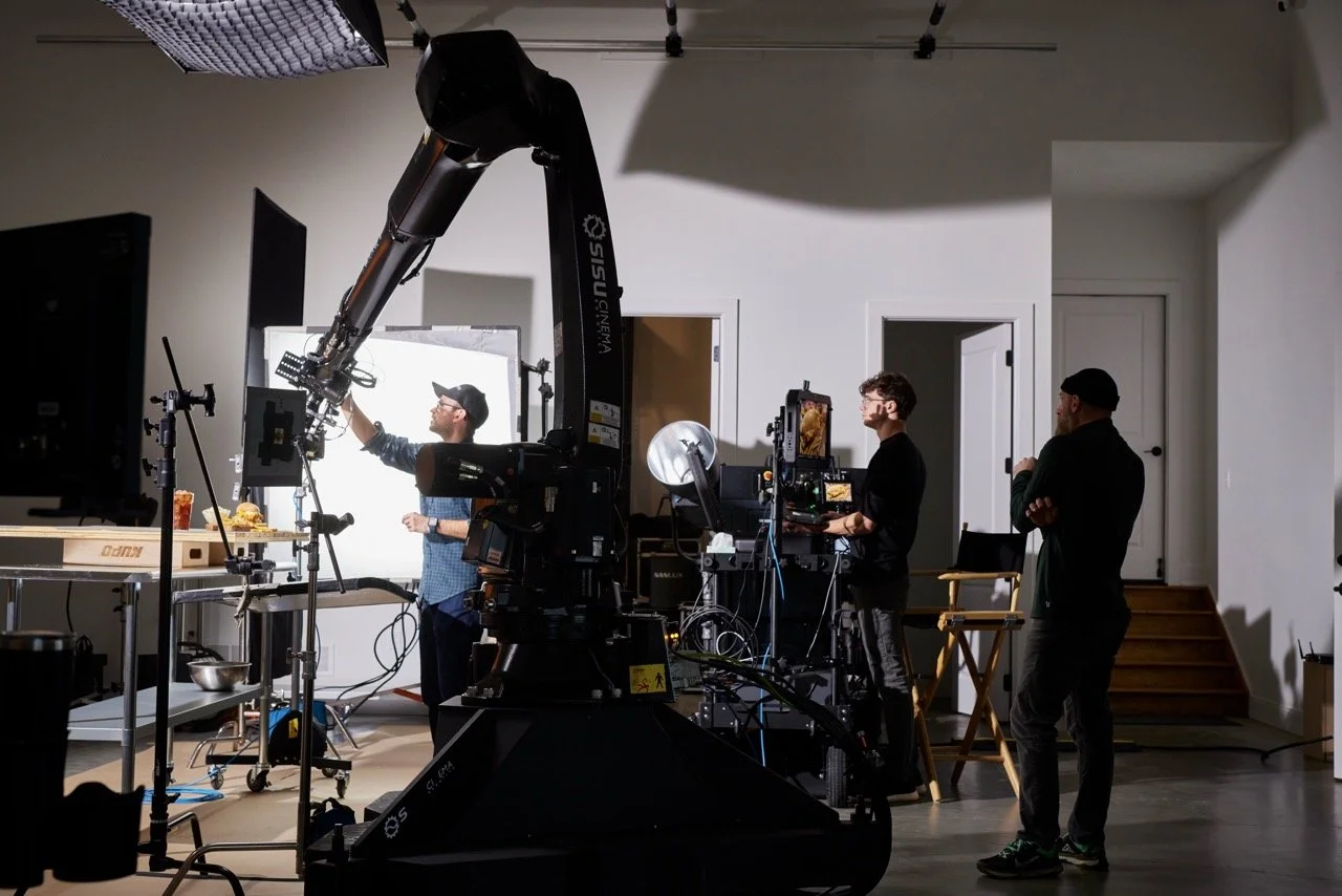 Video production crew operating camera equipment inside a studio.  Motion control camera robotics.