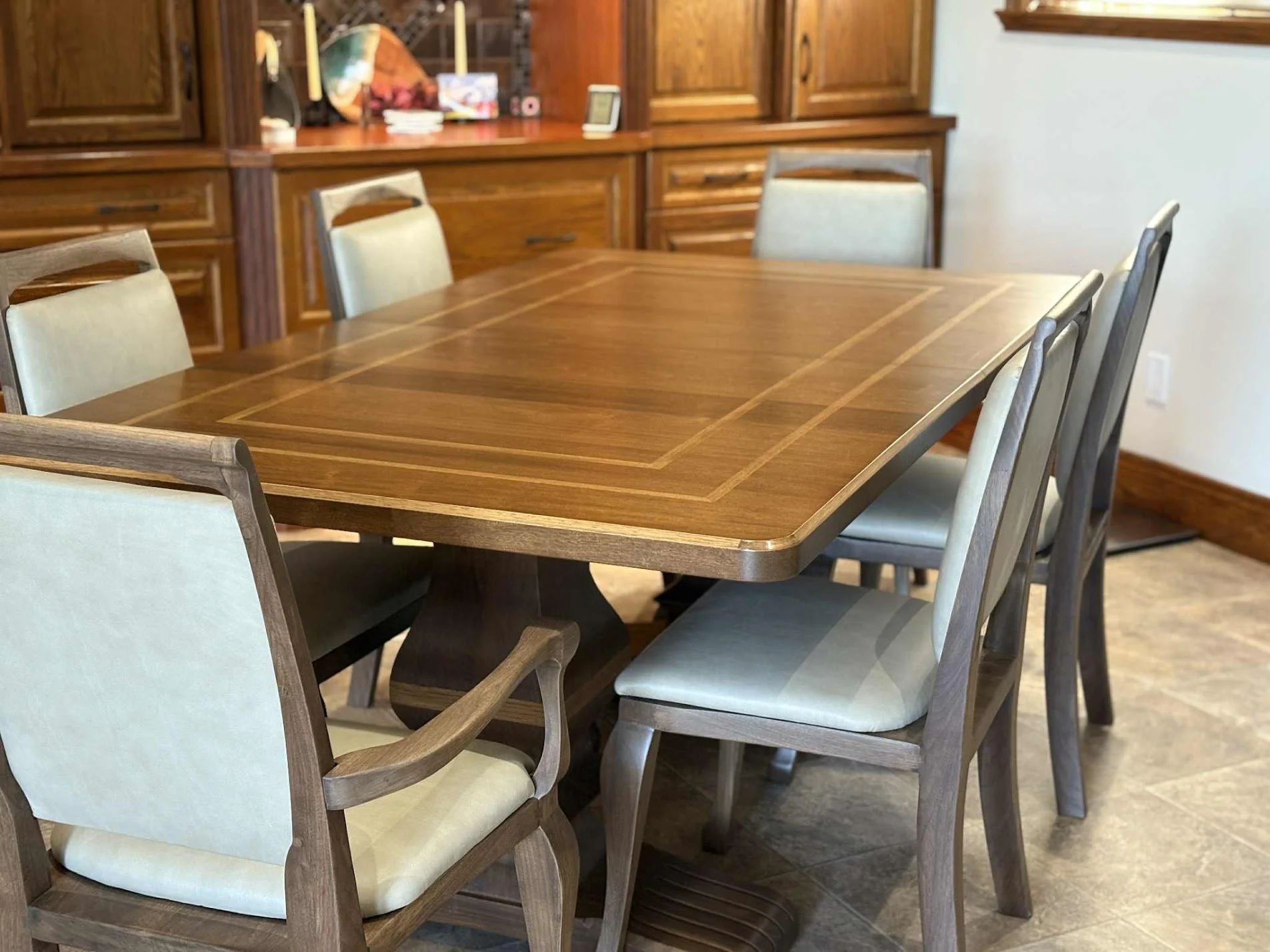 Artesão Windsor dining chairs in walnut with Ultraleather upholstery around a dining table