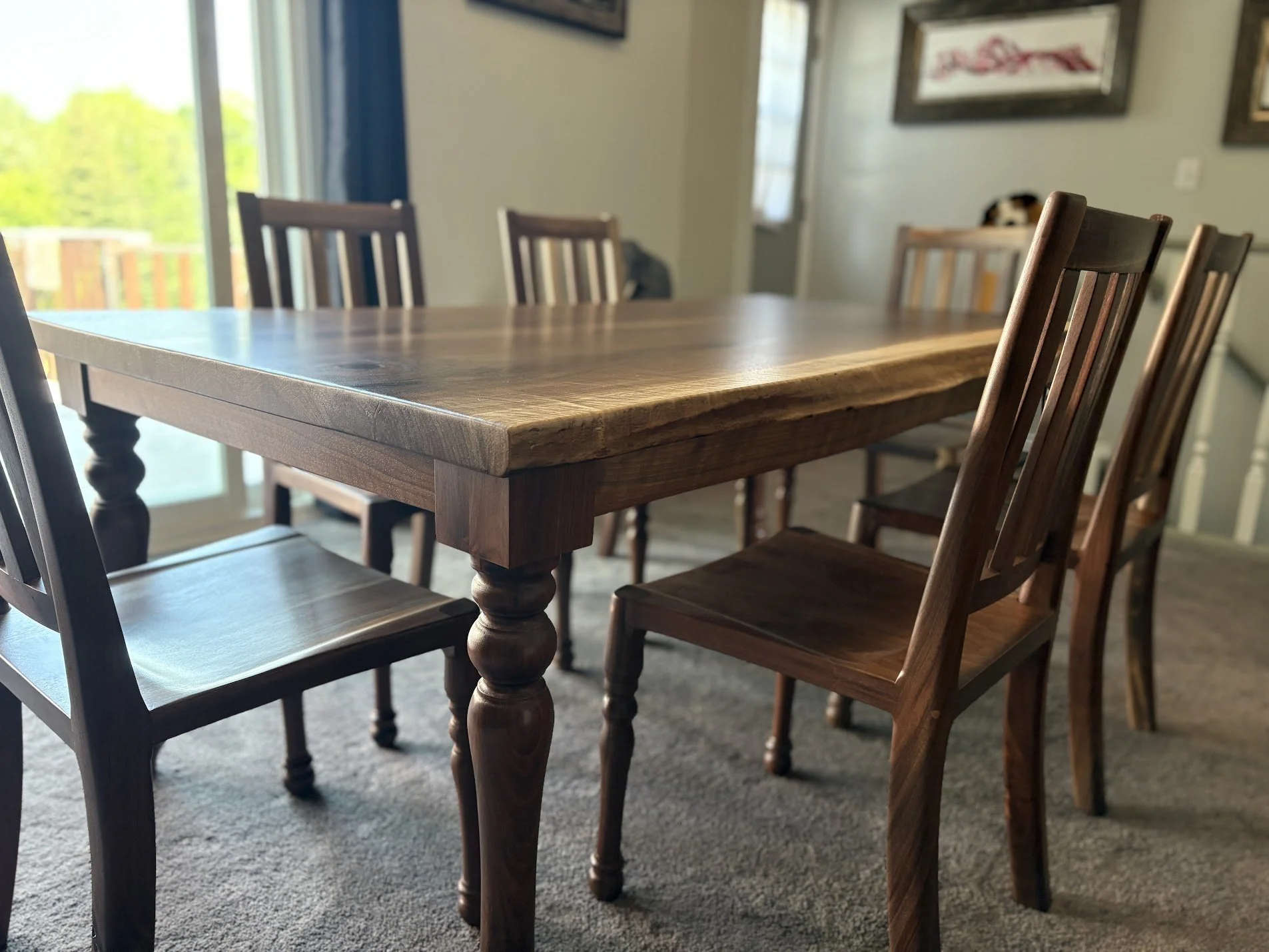 Artesão Traditional dining chair in walnut with turned legs at a live-edge walnut table