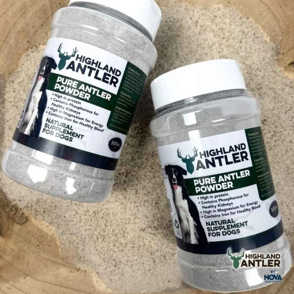 Two jars of Highland Antler pure powder positioned over loose, finely ground antler supplement spilled onto the rustic wooden board.