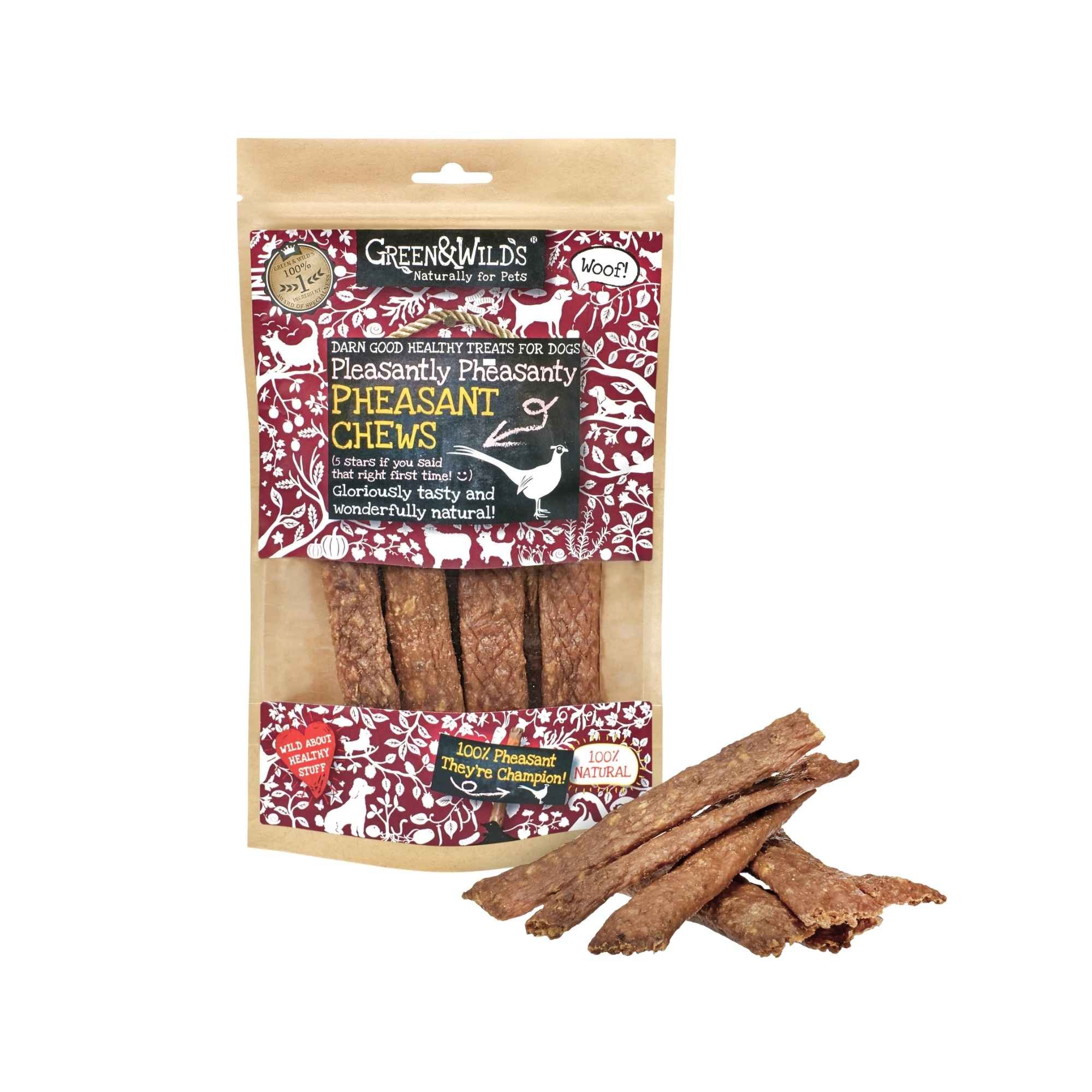 Green & Wild's Pheasant Chews dog treats pouch standing on a white background next to a stack of dried pheasant strip chews.