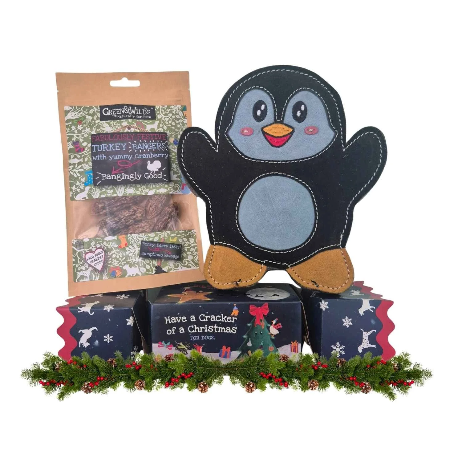 Green & Wild's Festive Turkey Bangers pouch and a Christmas cracker presented with a black Aurora Paws eco suede penguin dog toy and pine garland.