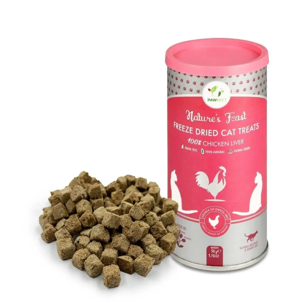 A tall pink tub of Pawfect Nature's Feast freeze-dried chicken liver cat treats next to a pile of freeze-dried meat cubes.