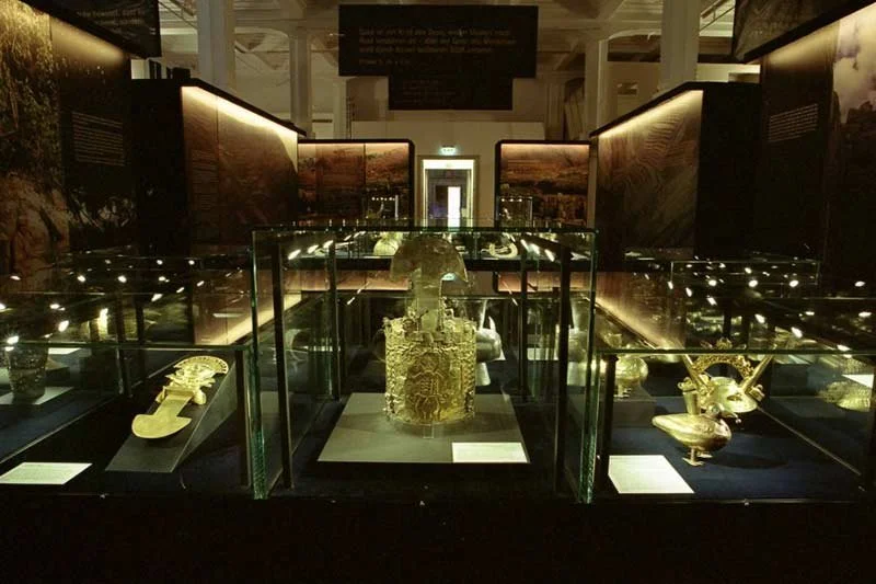 Display of ancient gold jewelry and artifacts in a museum exhibit case.