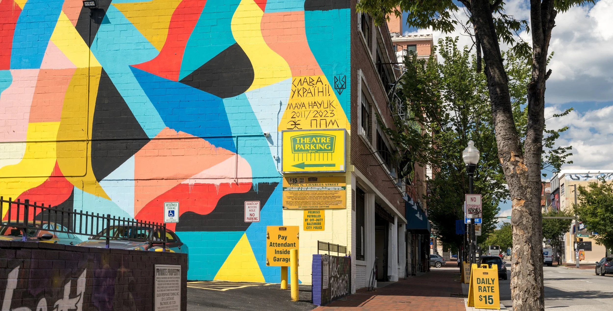 Theatre Parking signage and mural showing daily parking information on North Charles Street.