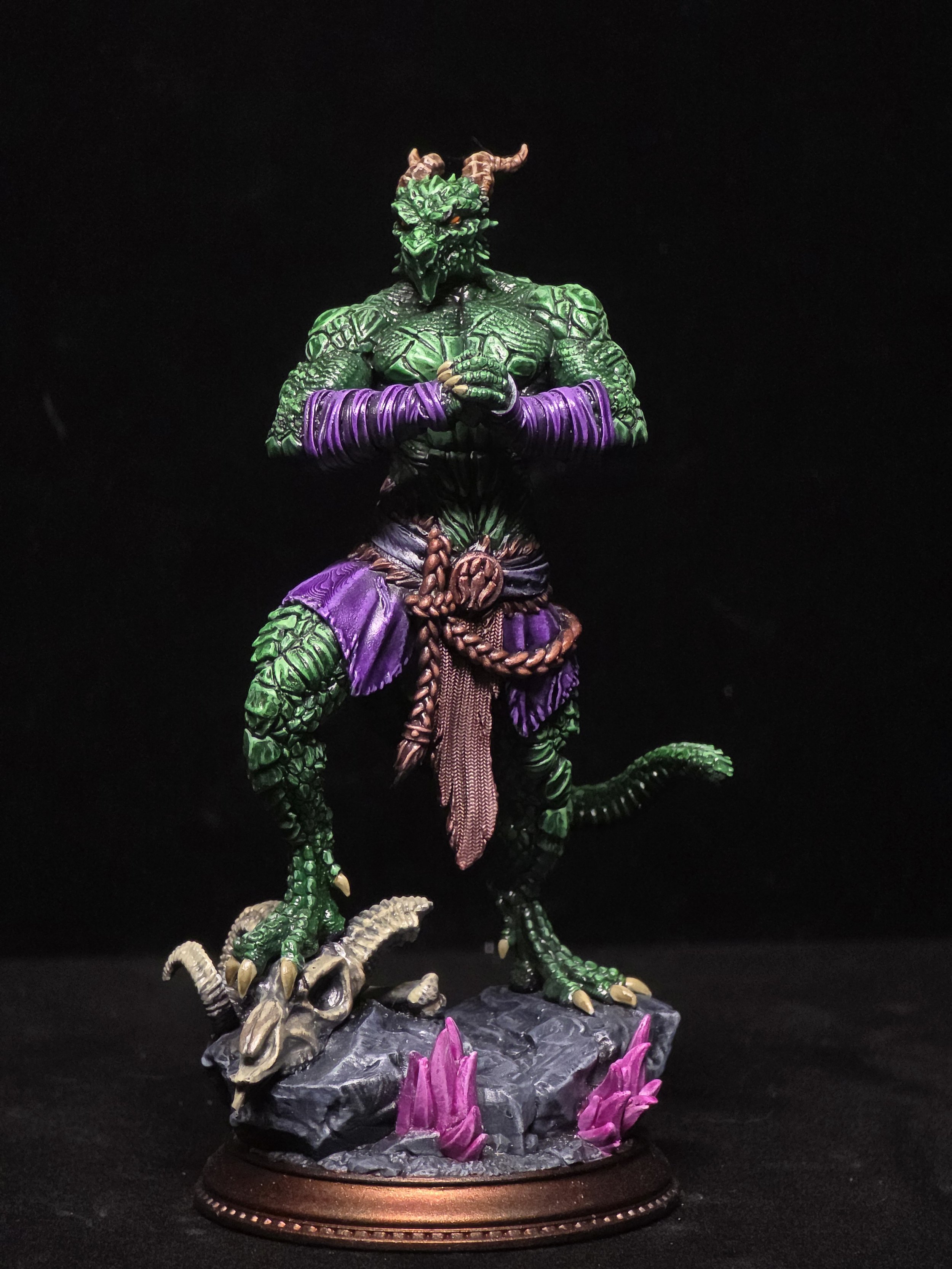 A detailed model of a green dragon humanoid with horns, dressed in purple and brown cloth, standing on a rocky base with purple crystals, against a black background.