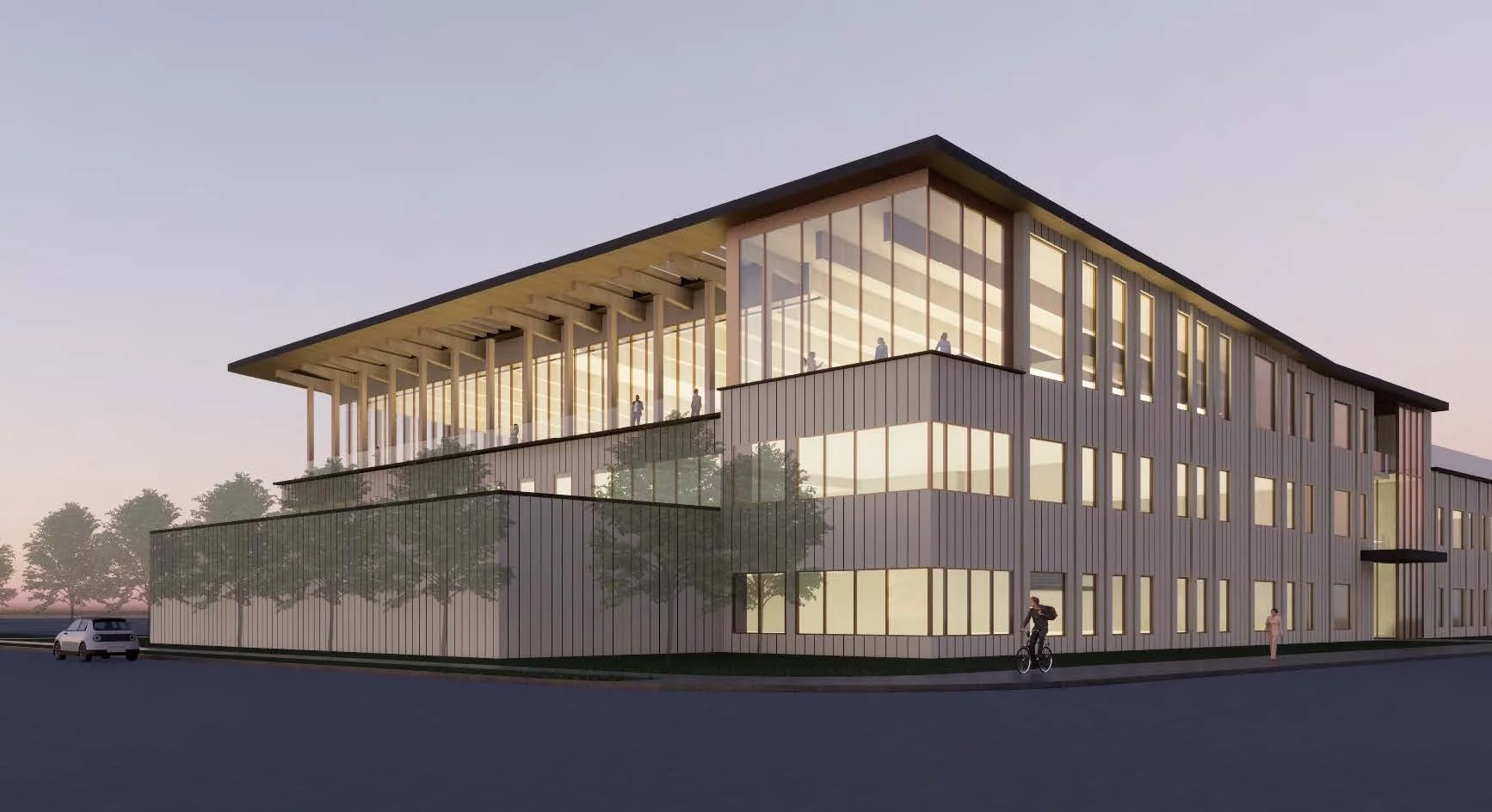 A modern multi-story building with large glass windows, an overhanging roof, and a terrace on the top floor. There are trees and a street with a person riding a bicycle and another walking nearby.