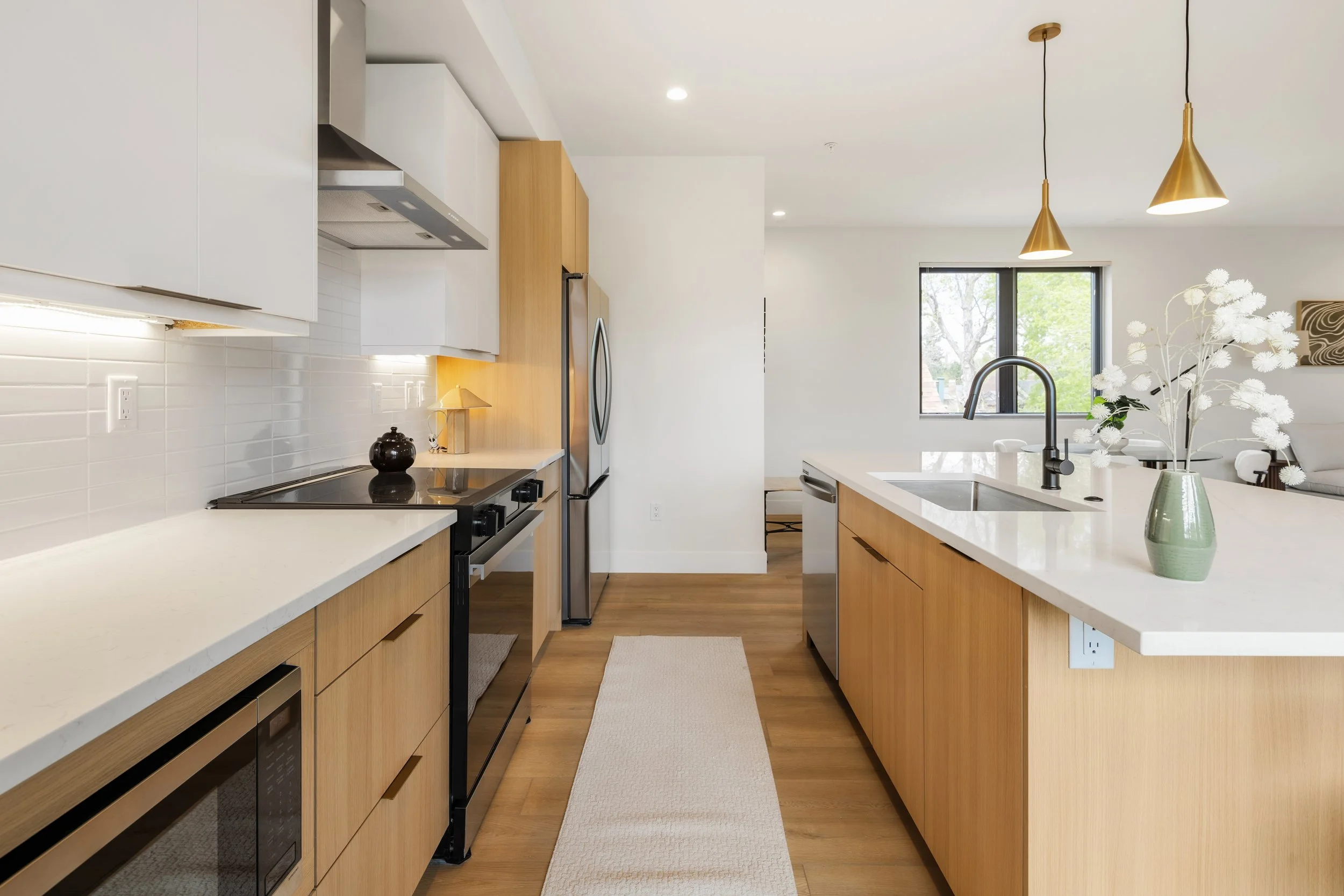 Kitchen in 2-bedroom Denver condo at Berkeley Residences featuring modern appliances, quartz counters, and open layout