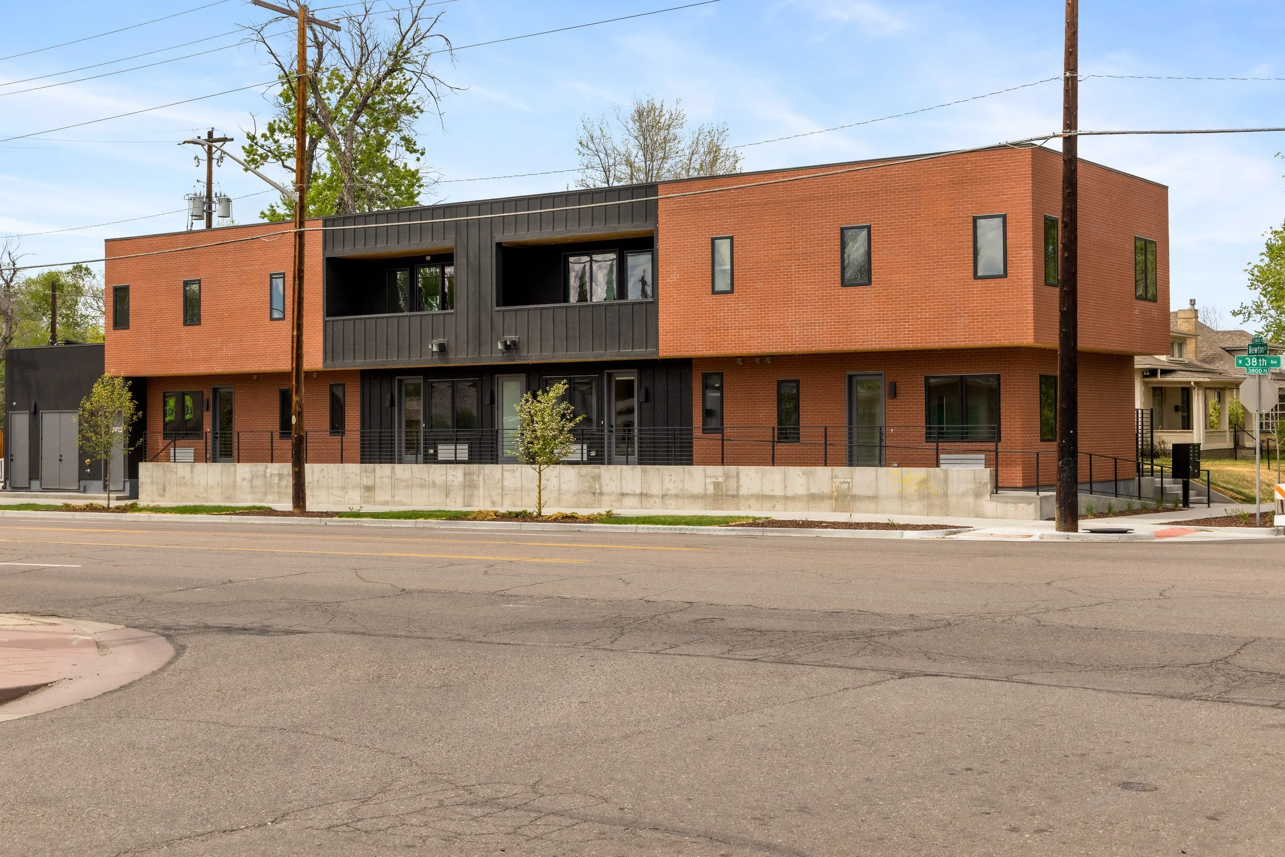 Modern brick and metal condo exterior at Berkeley Residences, 3825 W 38th Ave Denver CO, featuring contemporary architecture with large windows