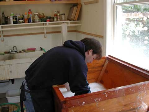 Step 1. Dipping the screen in the vat of pulp.	