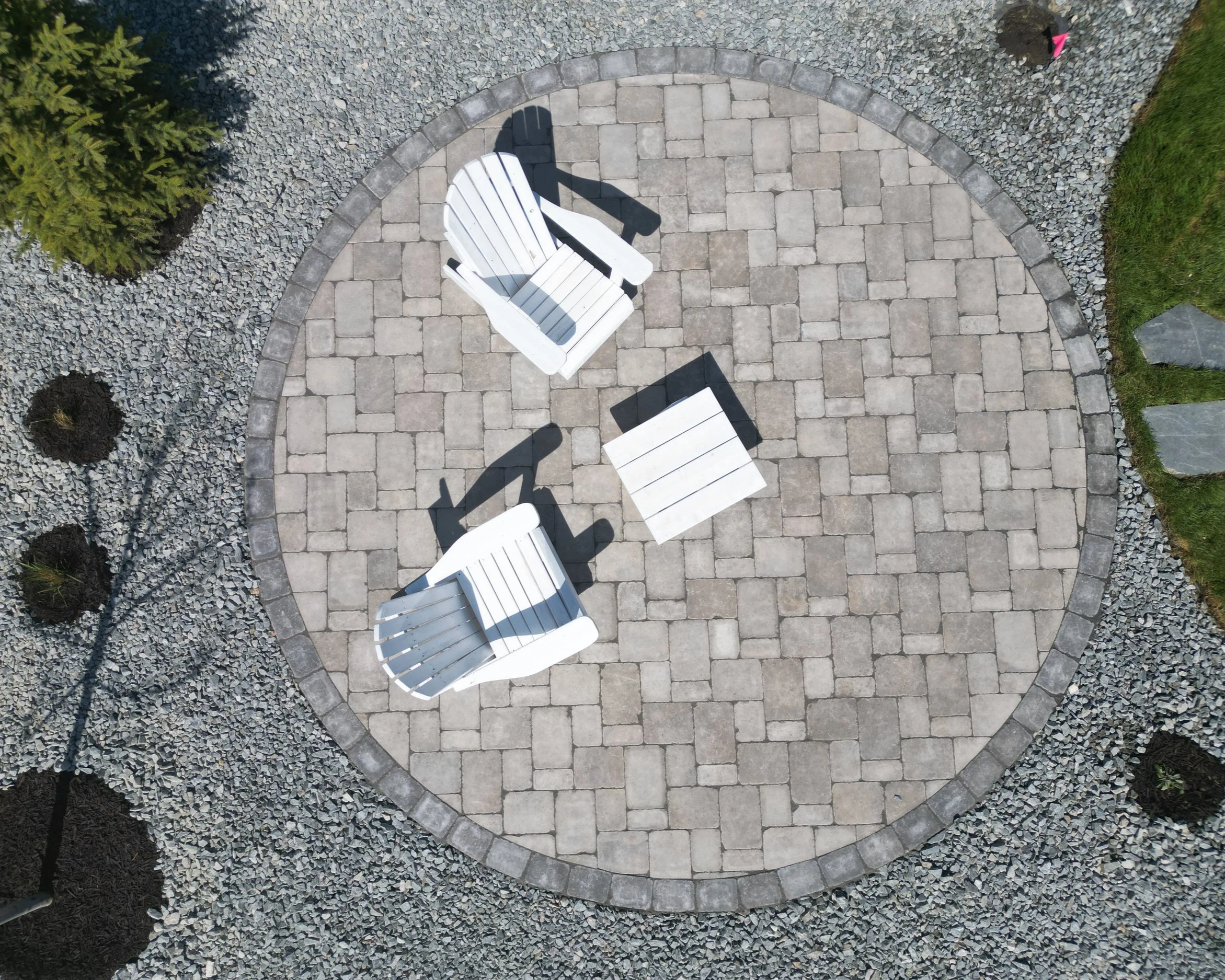 Round seating area with Roman pavers and decorative rock landscaping in Blind Bay, BC