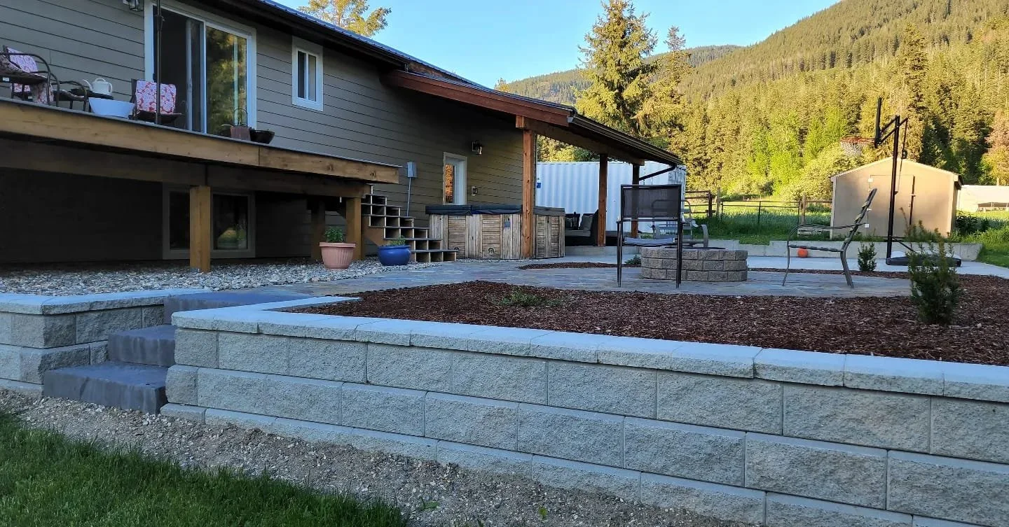 Retaining wall construction, landscape stairs, and patio installation completed for a residential property in the Shuswap.