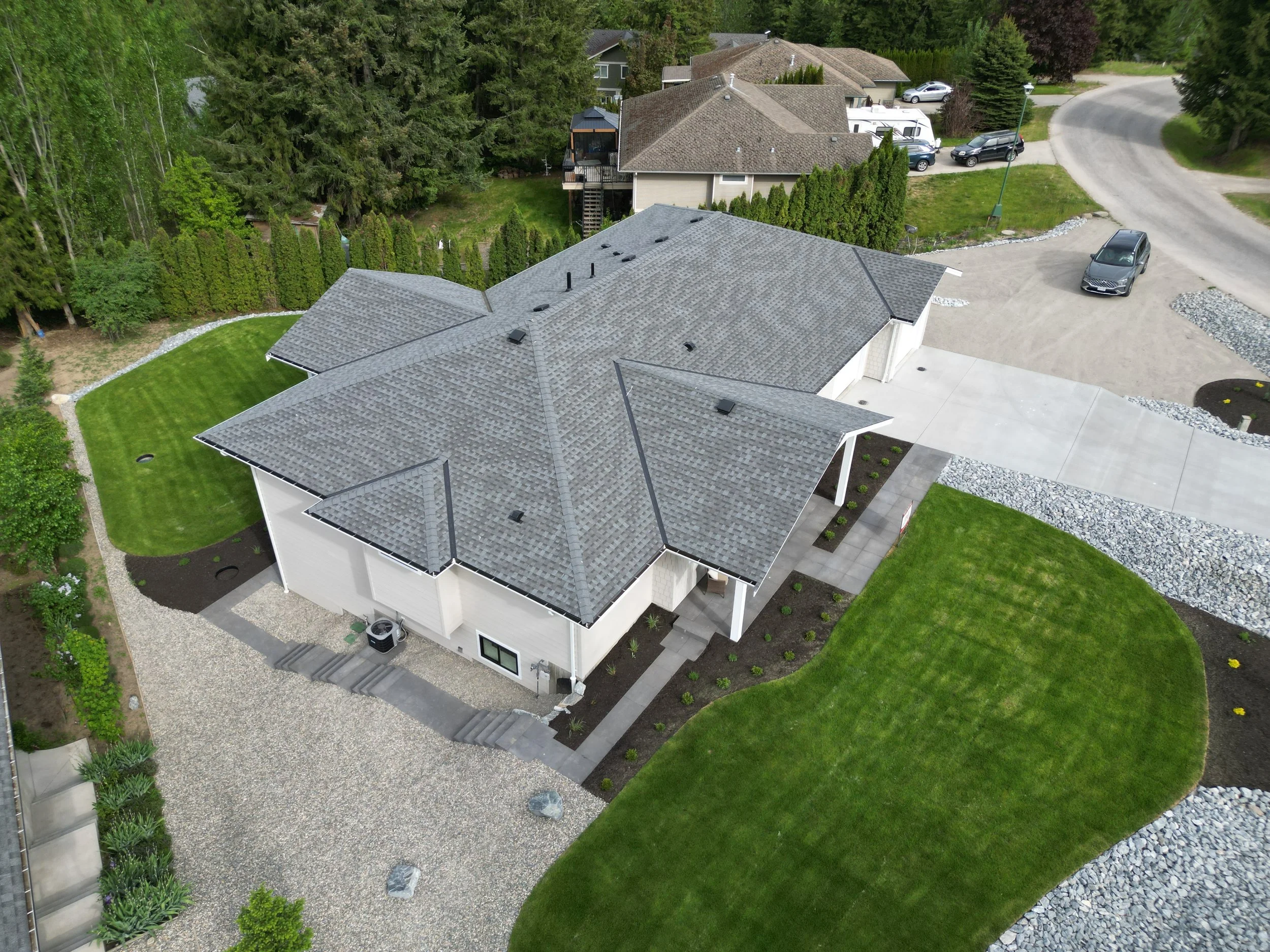 Residential landscaping project in Blind Bay, BC featuring decorative rock, paver installation, and softscape construction by Monarca Landscaping Ltd.