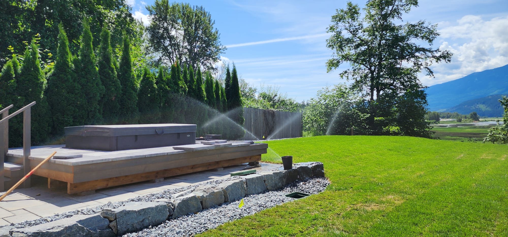 Luxury backyard landscaping with natural stone retaining wall and irrigation system in Blind Bay, BC