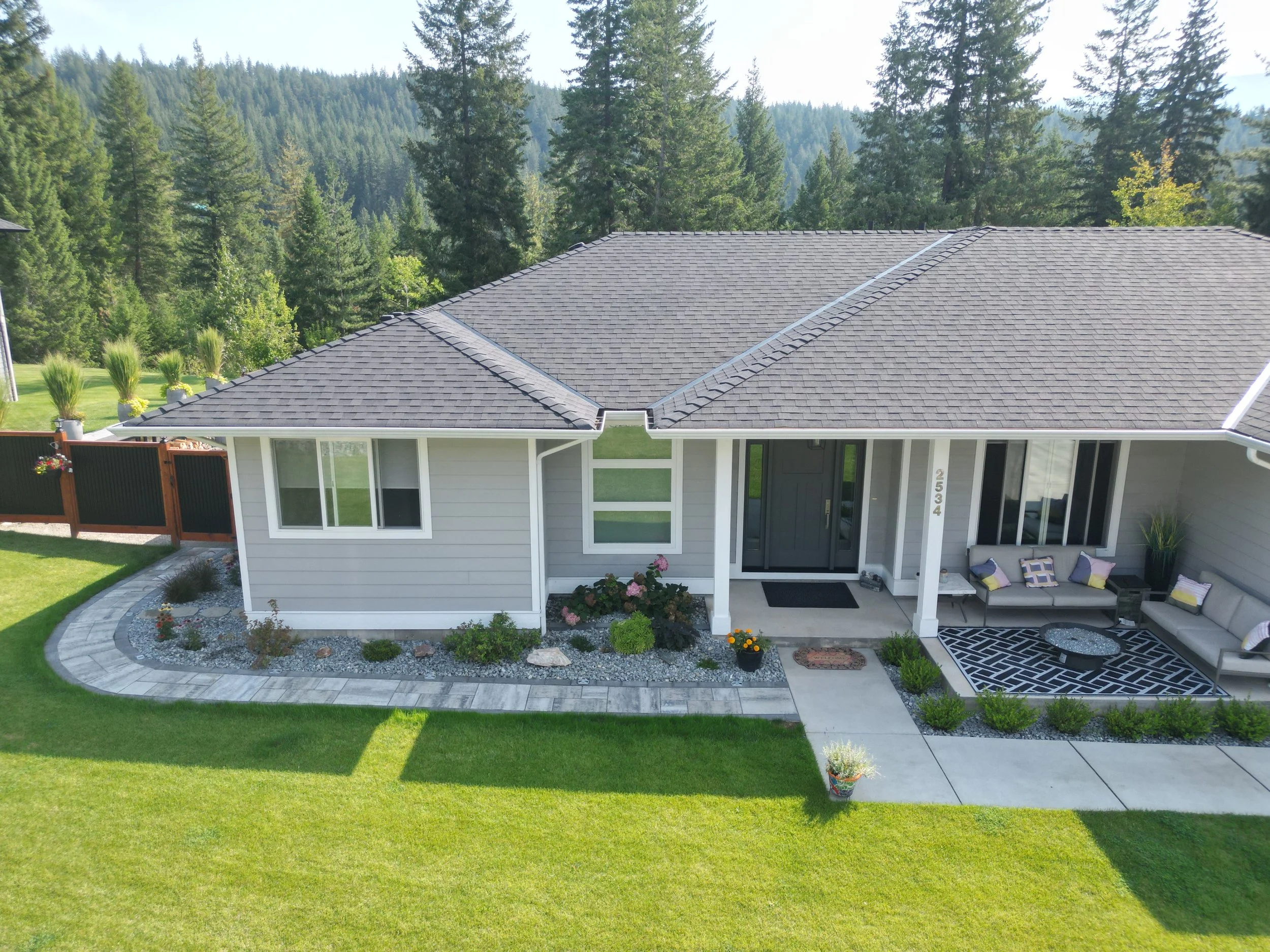 Front yard landscaping project in Blind Bay BC featuring paver walkway, decorative rock, garden beds and modern landscape design by Monarca Landscaping.