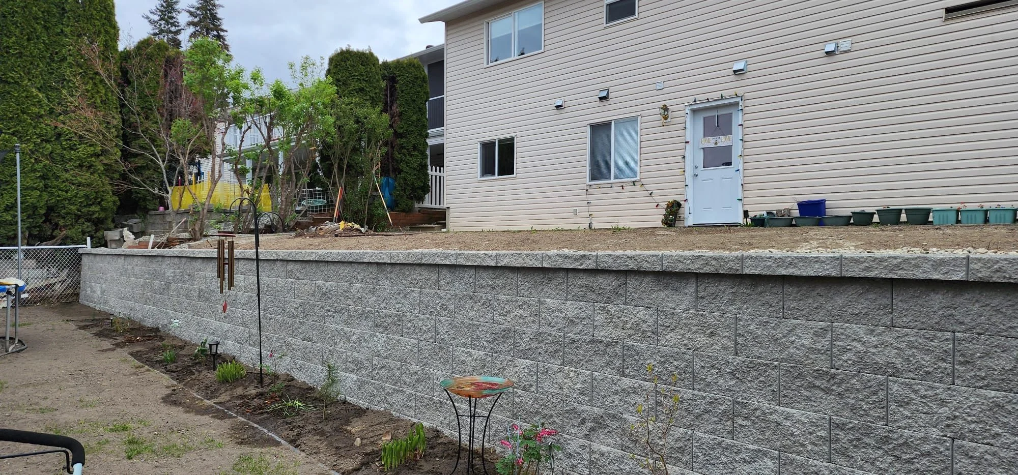 Retaining wall repair and reconstruction with drainage improvements for a sloped residential property.