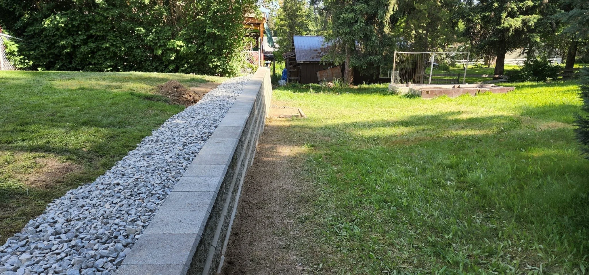 Retaining wall rebuild replacing a failing landscape wall with proper drainage and structural support.