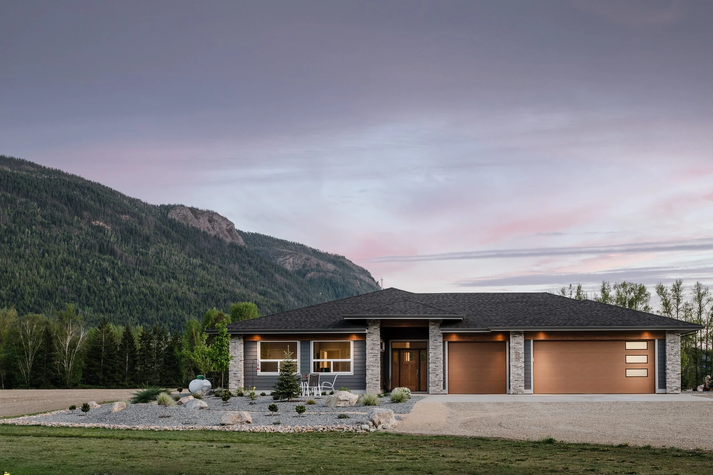 Modern front yard landscaping project in Salmon Arm BC featuring decorative rock, low maintenance xeriscape landscaping and custom home landscape design by Monarca Landscaping.