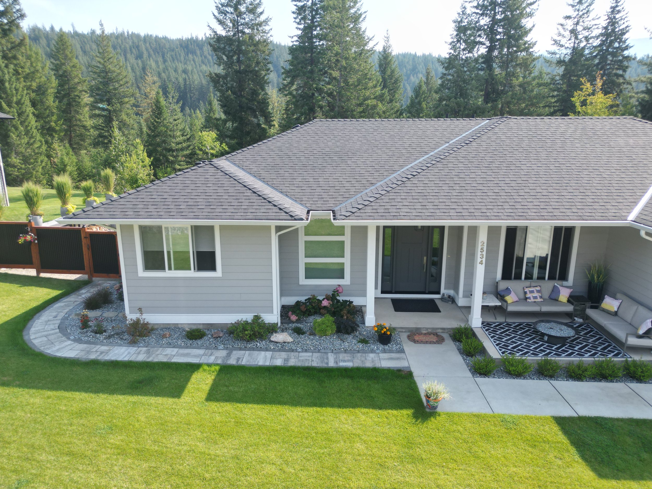Front yard landscaping project in Salmon Arm BC featuring paver walkway, decorative rock, garden beds and modern landscape design by Monarca Landscaping.