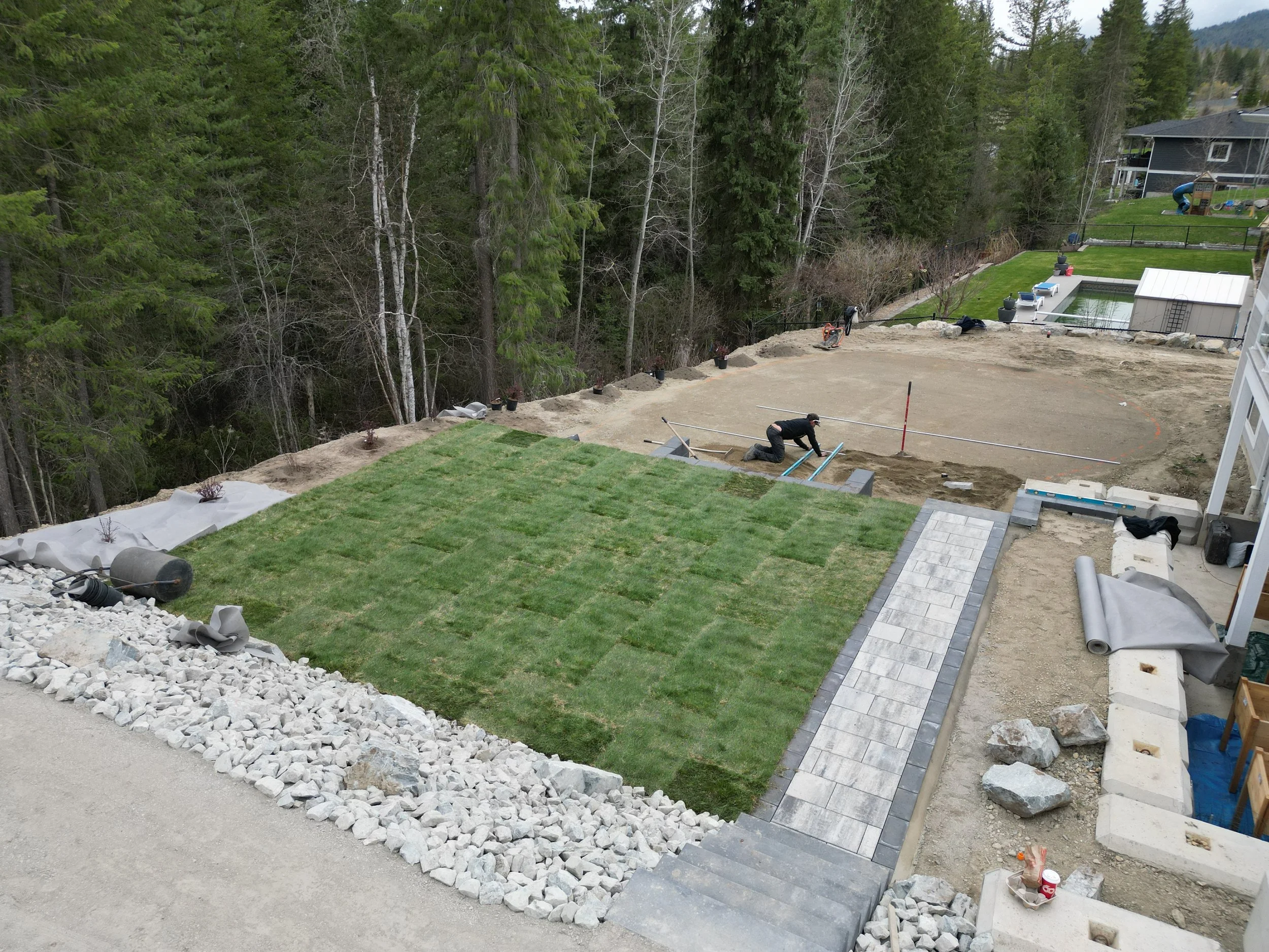 Complete backyard landscape installation with lawn, stairs and walkway in Blind Bay BC