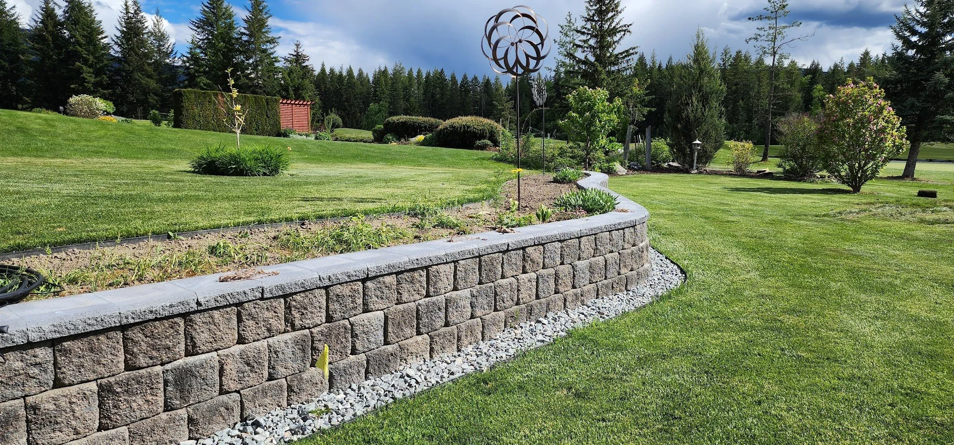 Retaining wall reconstruction replacing a failing wall with a properly engineered retaining wall system and drainage.