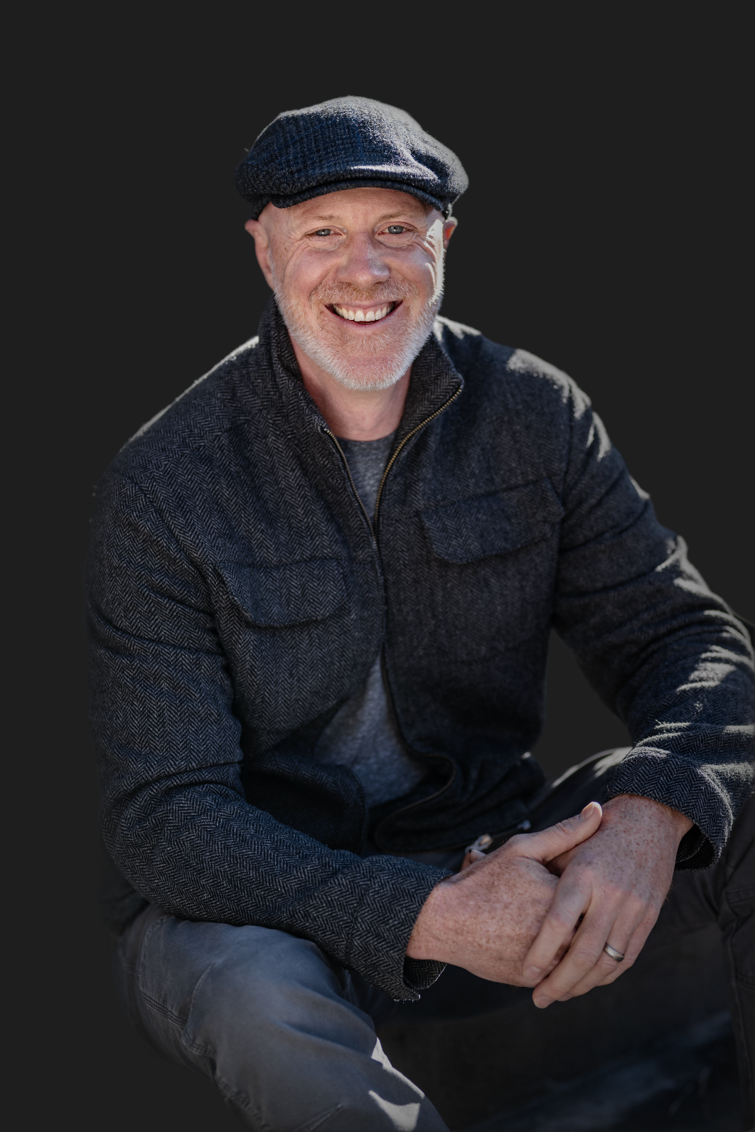 Evan Hendrix, marriage coach for men in Leiden, smiling in a flat cap and herringbone jacket