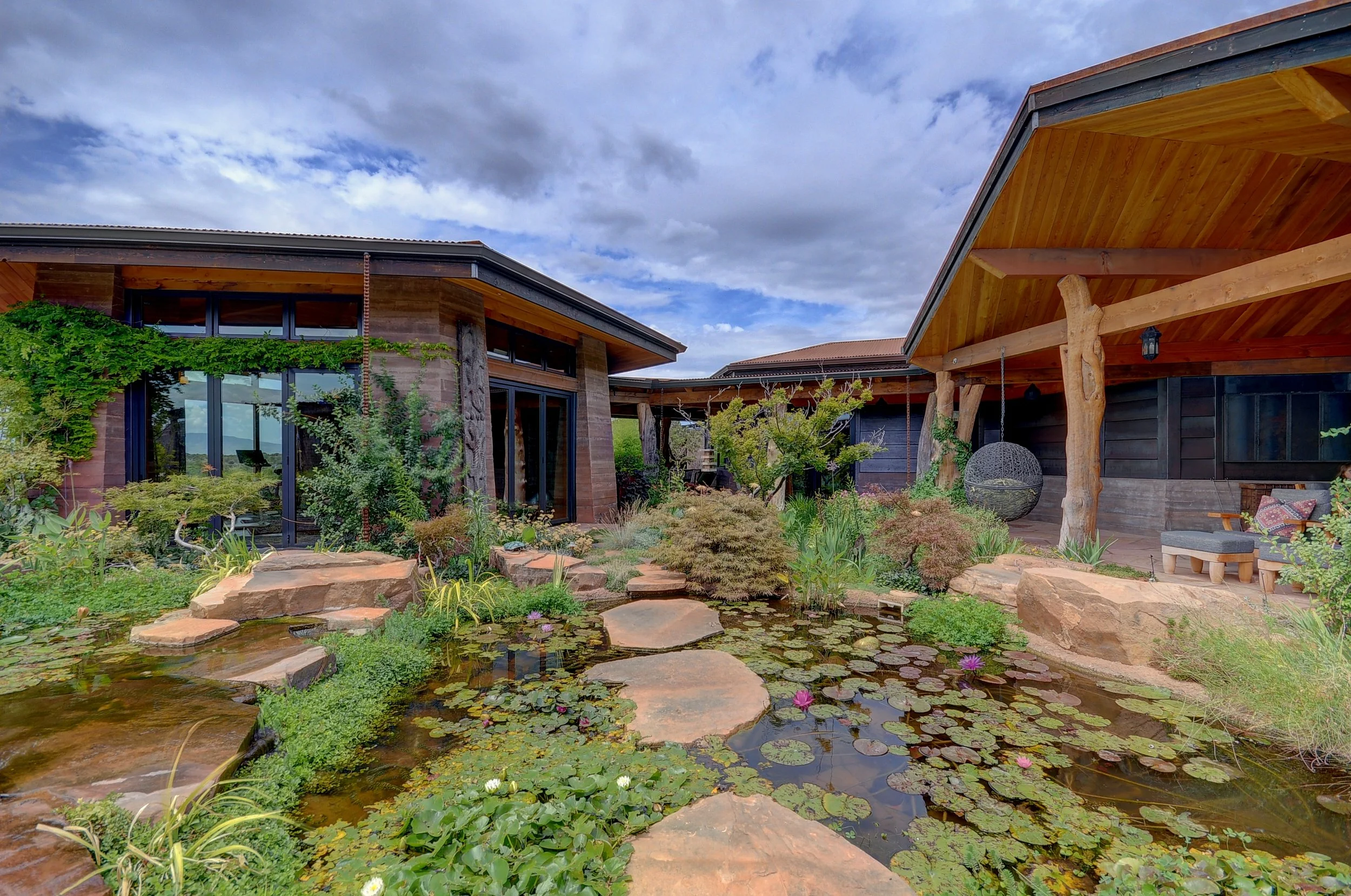 Intimate courtyard space nestled between octagonal building masses with exposed wood framing and relaxed outdoor spaces. 