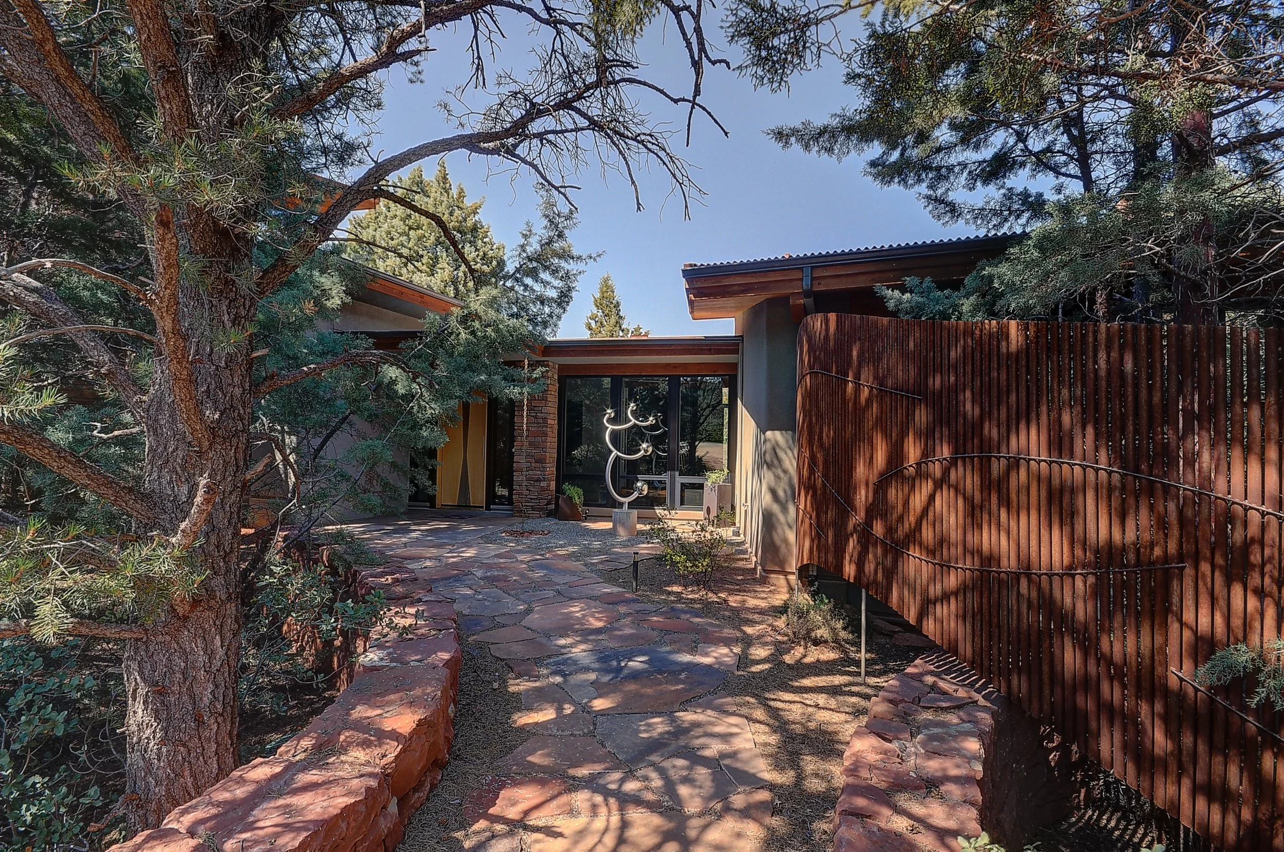 A private entry with a custom landscape sculpture welcomes you into a sensible, modern home. 