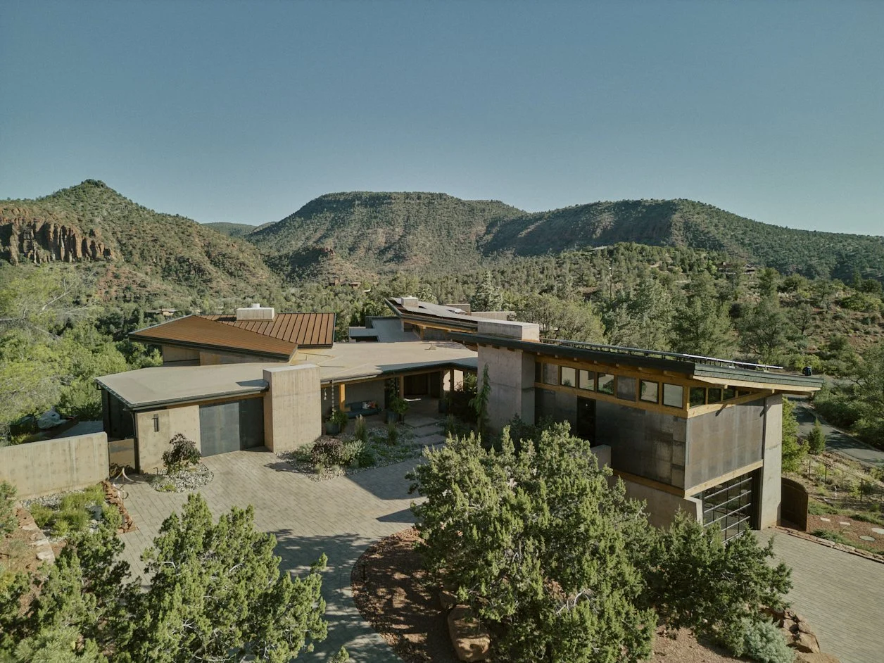 Modern house with flat and sloped roofs, with a view of Sedona, Arizona beyond.