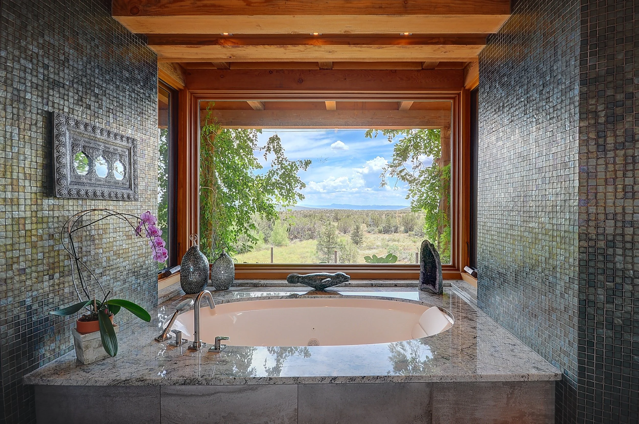 Large, tiled bathtub in with adjacent window in bathroom showing the magnificent landscape of Sedona, Arizona.