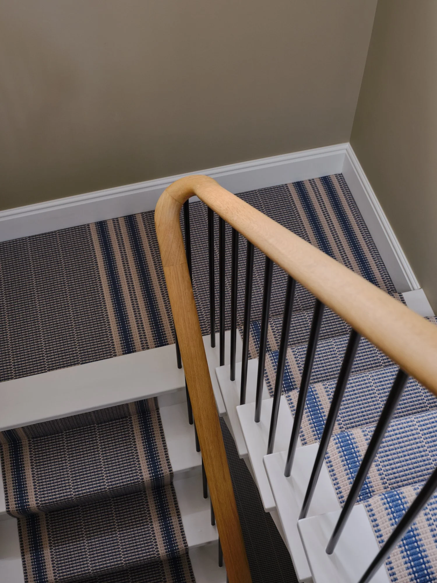 Striped stair runner and handrail viewed from above at a house renovation on Priory Road, Chiswick, W4 by Robin Services.